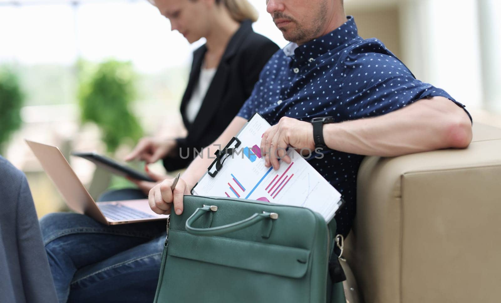 Man and woman with documents charts and laptop working at airport closeup by kuprevich