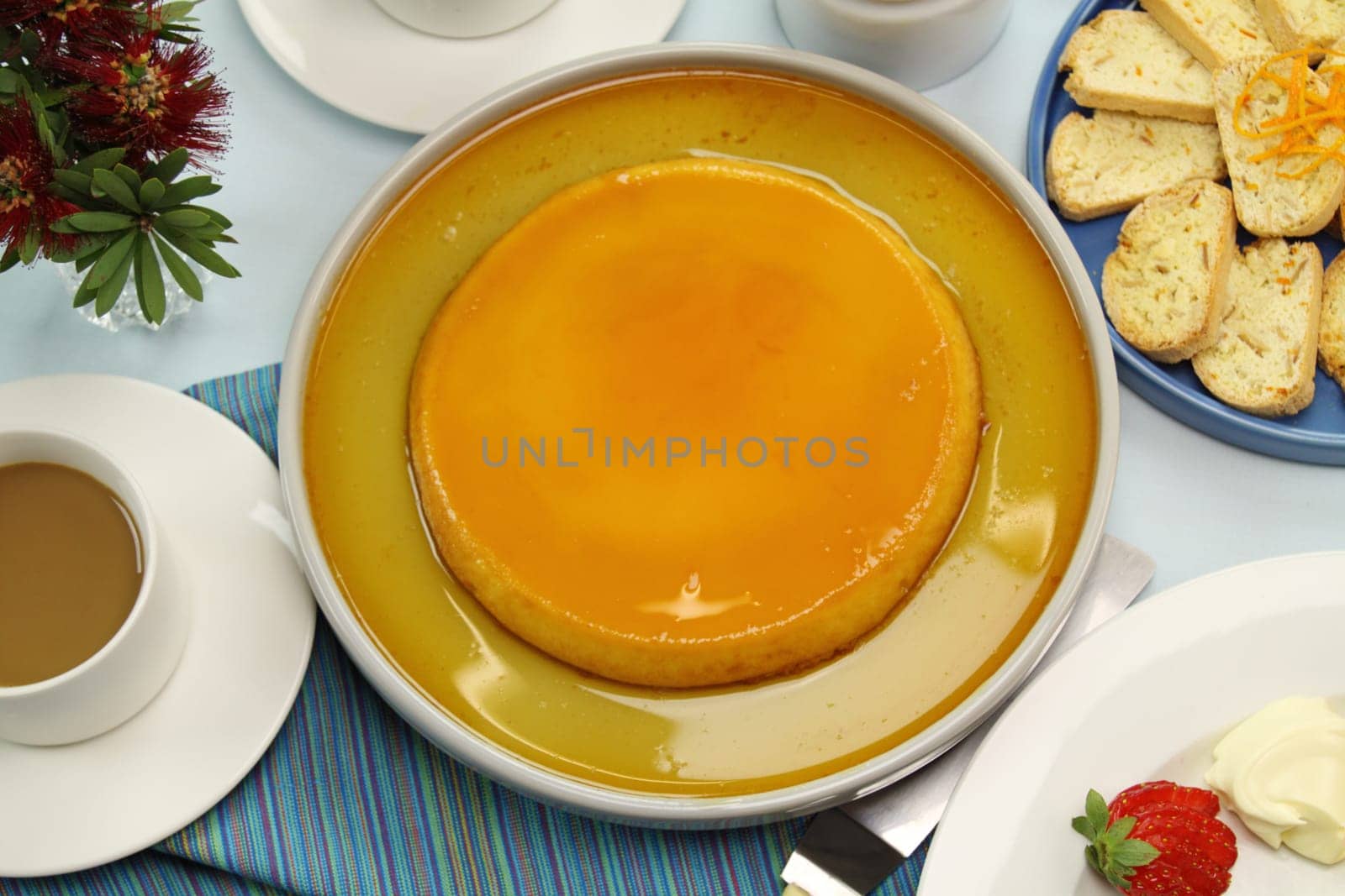 Creme caramel ready to be served with coffee and strawberries.