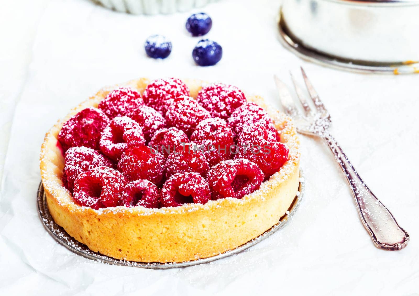 Summery Raspberry Pie and a cake pan on white background