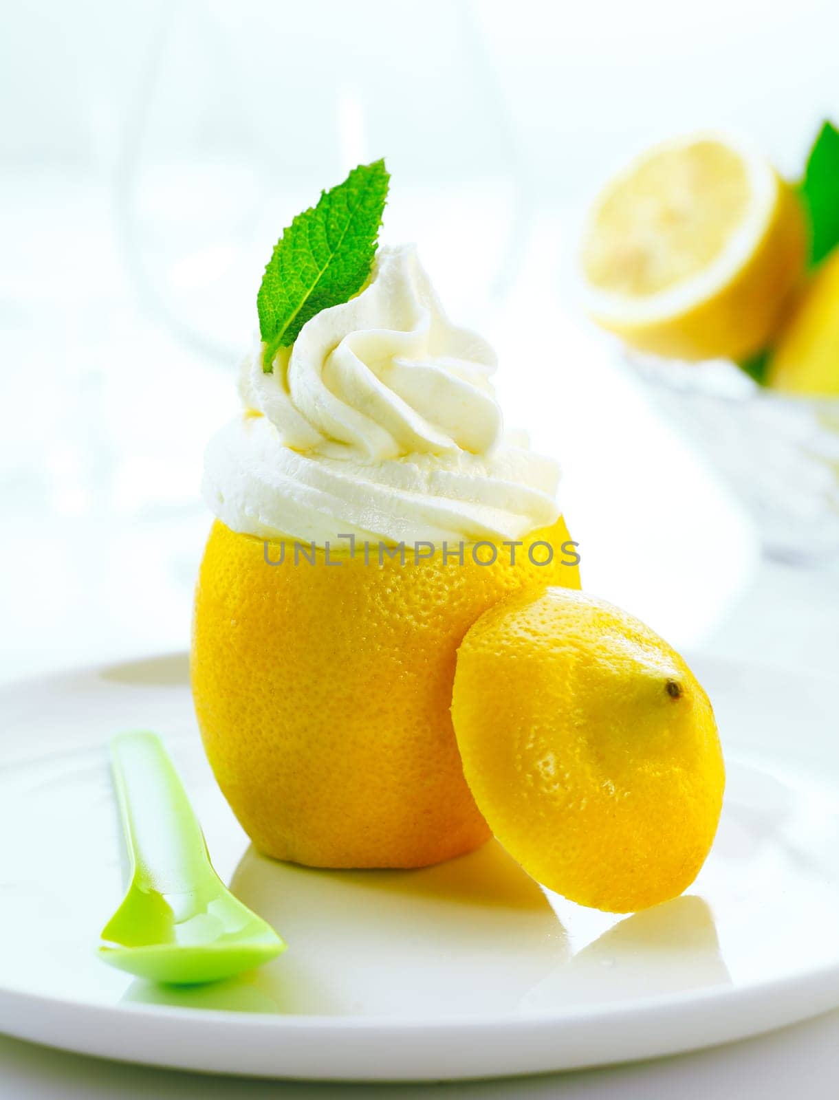 Fresh creamy icecream served as a topping on a sliced fresh lemon for a cool refreshing dessert