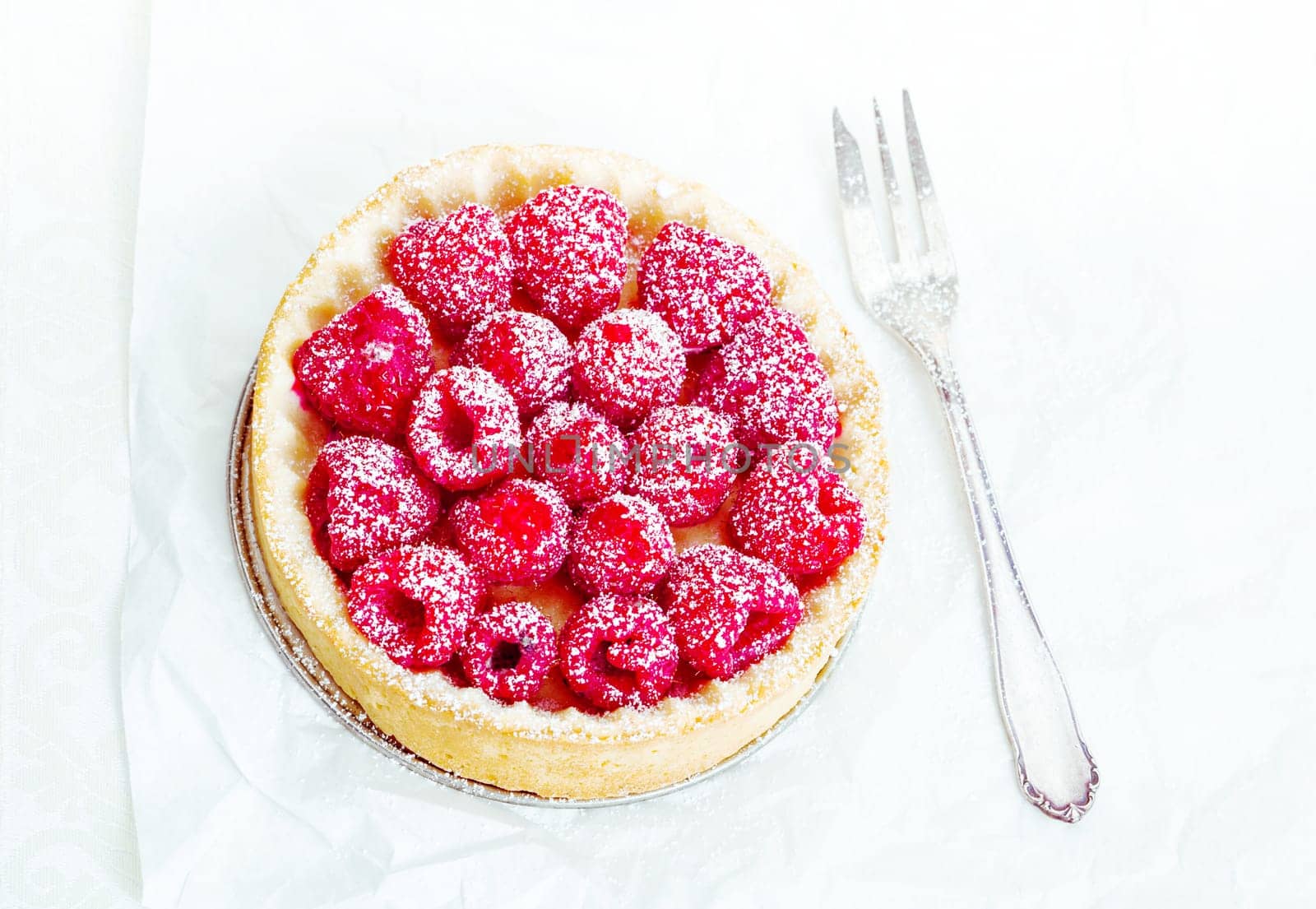 High angle Fruity Tart with delicious raspberries and powdered sugar