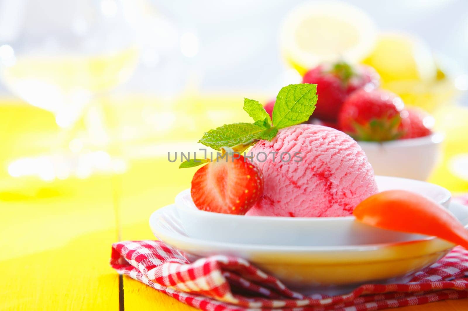 Tropical strawberry icecream served with fresh ripe strawberries in a tabletop setting on a summer vacation