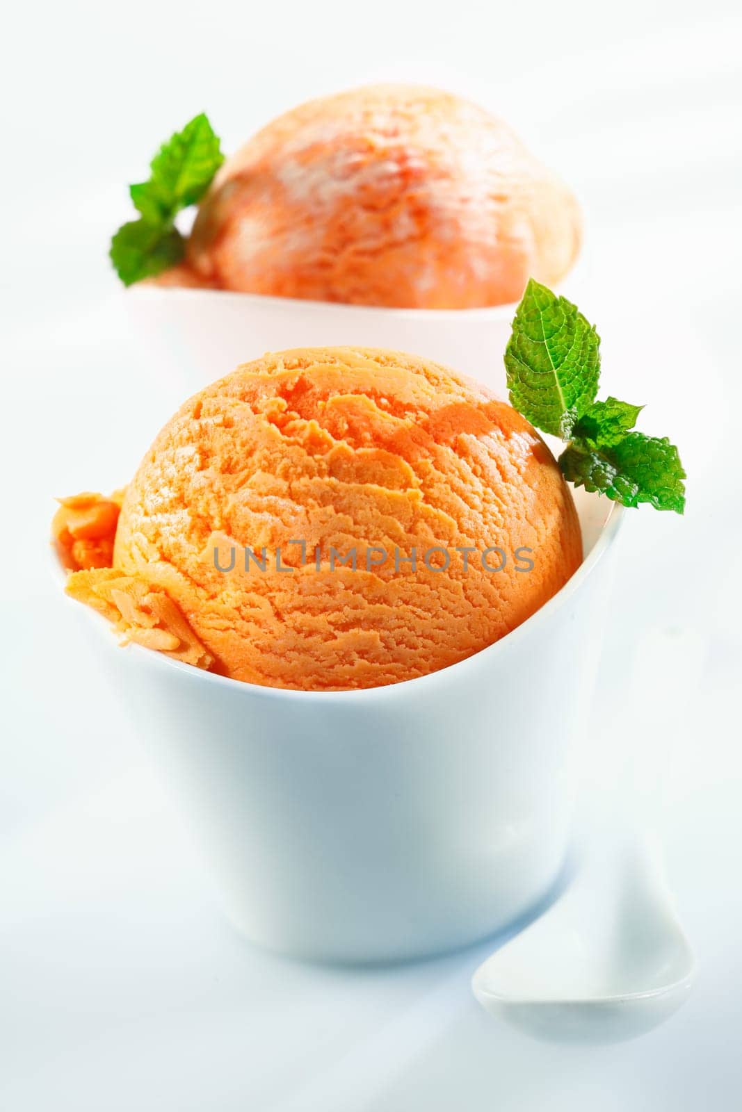 Orange scoops of icecream on white background. For ice-cream concept look at my portfolio