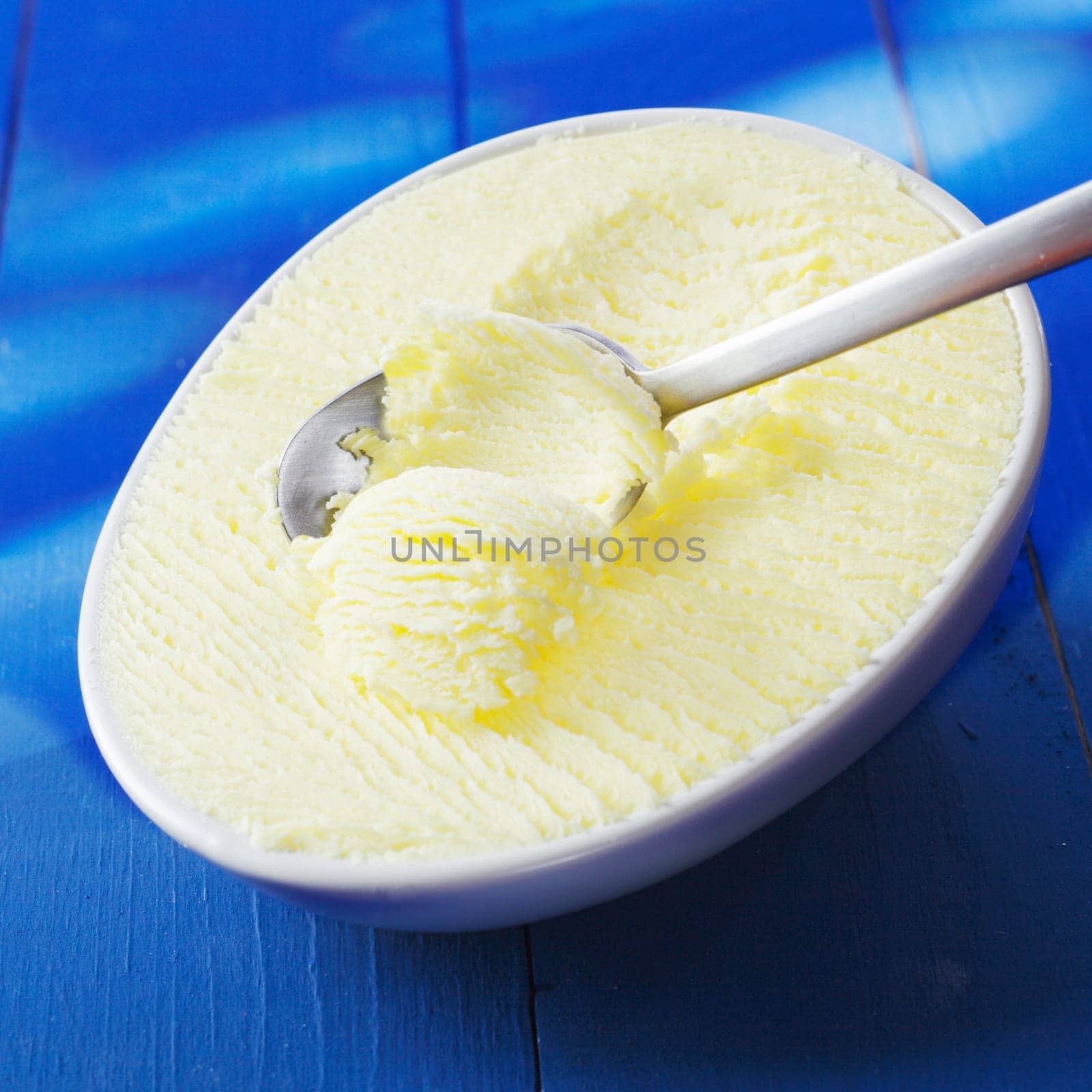 Vanilla Icecream Dessert in a bowl on a blue wooden background. For ice cream concepts look at my portfolio