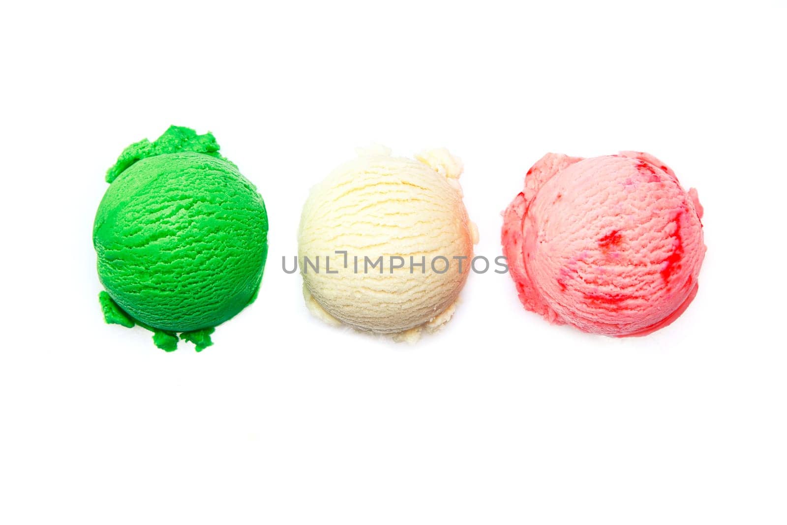 Variety of Italian icecreams with individual scoops of three different flavourings in green , pink and white lined up in a row isolated on white