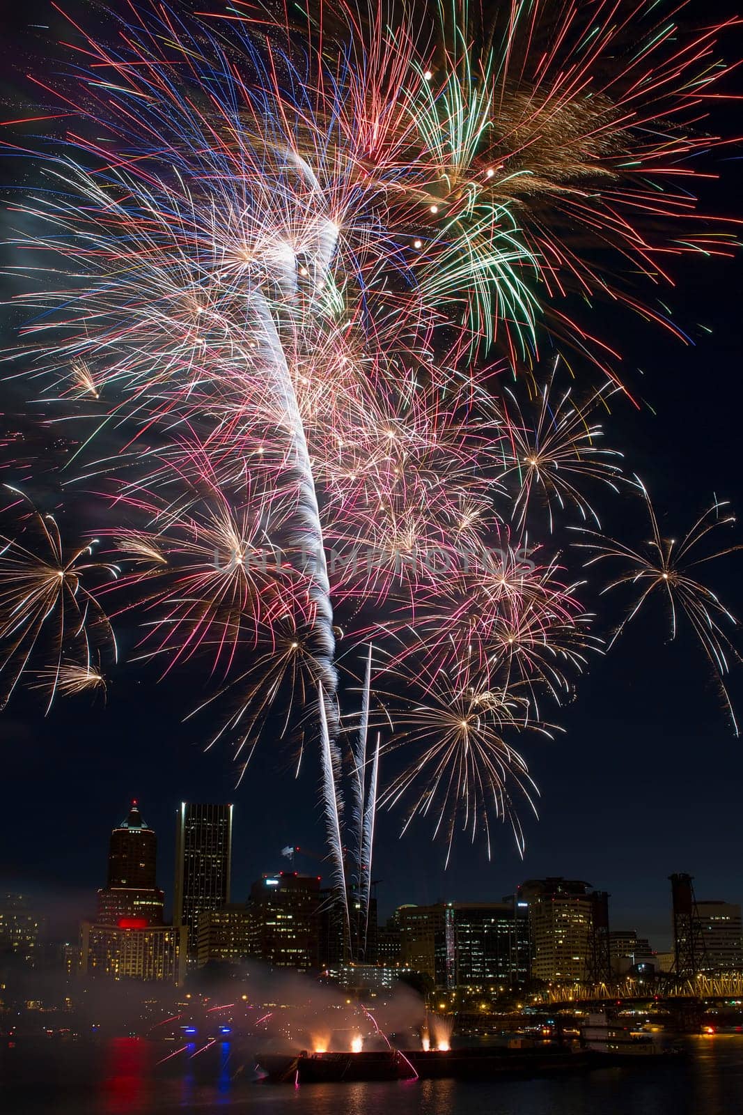 Multi-Color Fireworks Display Over Portland Oregon Skyline Along Willamette River Waterfront at Night