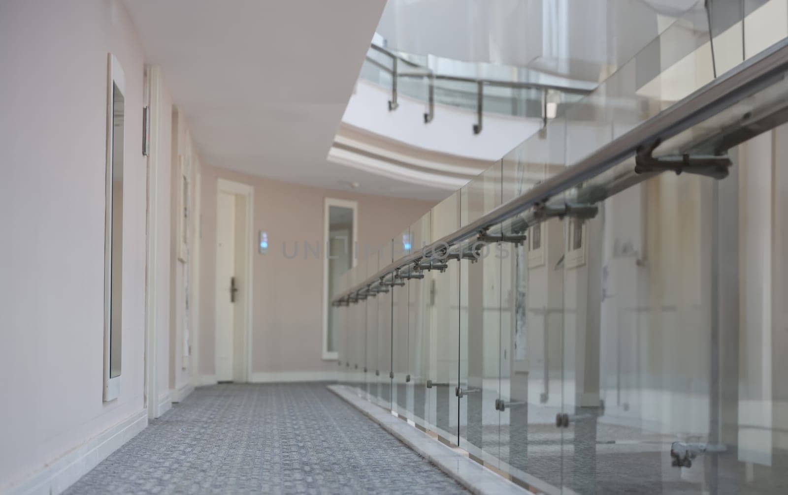 Empty corridor with doors to rooms in hotel building. Modern architecture public building concept