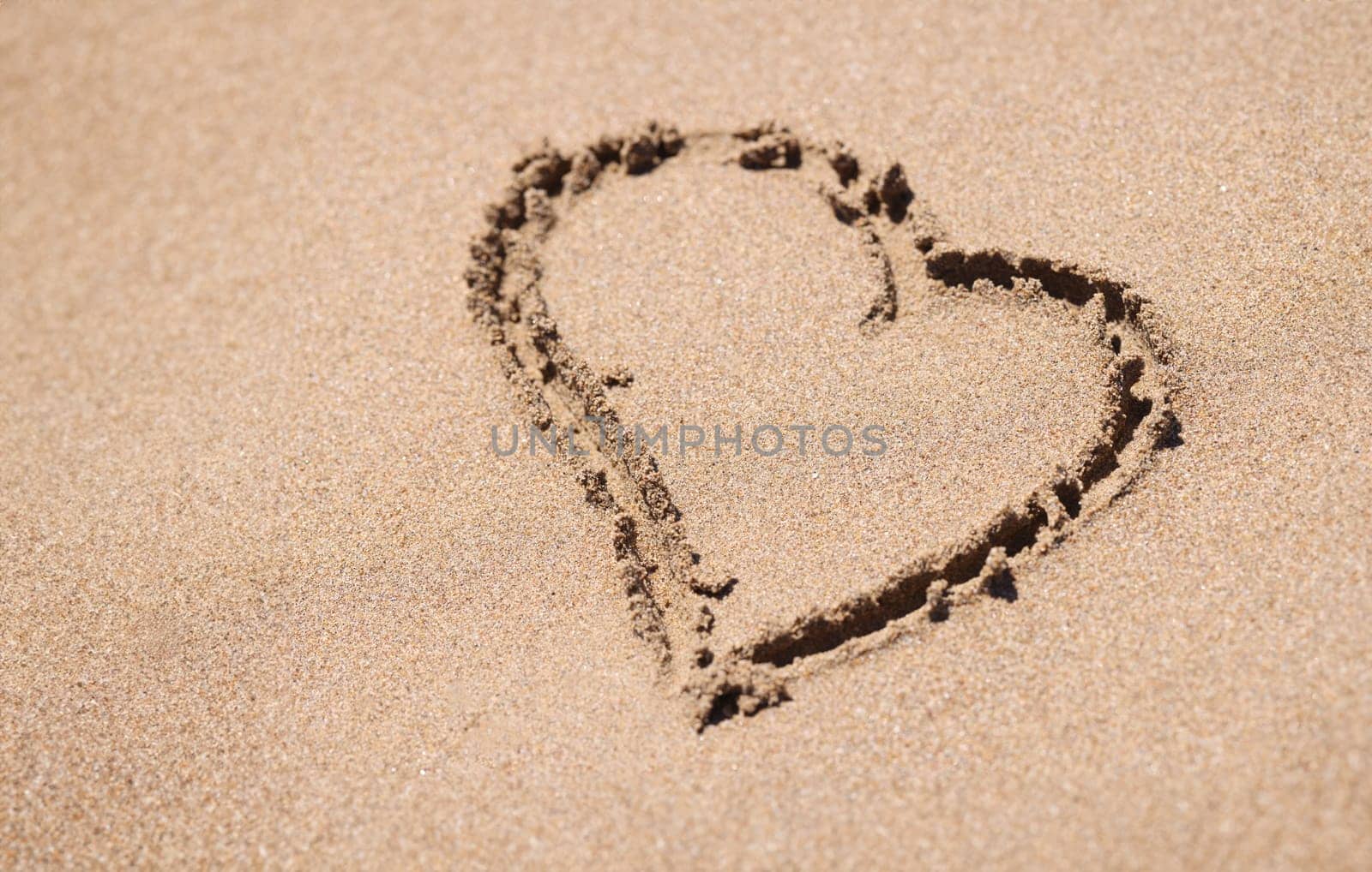Heart painted on sand of sea beach closeup. Honeymoon romantic trip concept