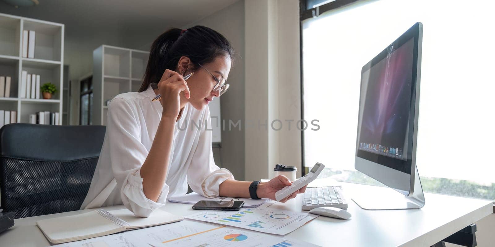 Portrait of beautiful young businesswoman asian sitting at office modern work station and typing on laptop.
