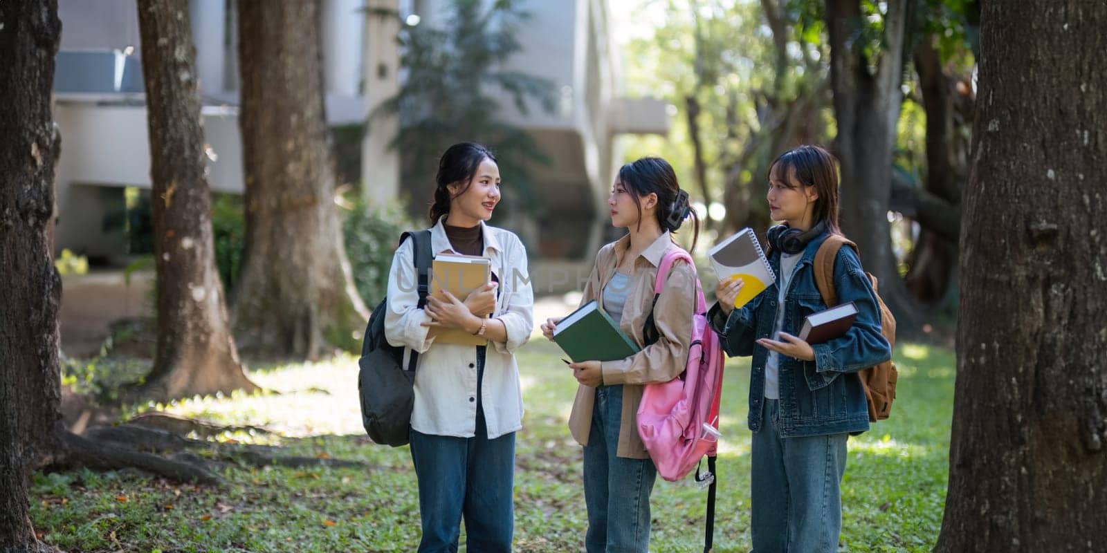 Happy young student chat with each other after class. Guy and girls wear casual clothes to study. Lifestyle College and University life concept, sincere emotions.