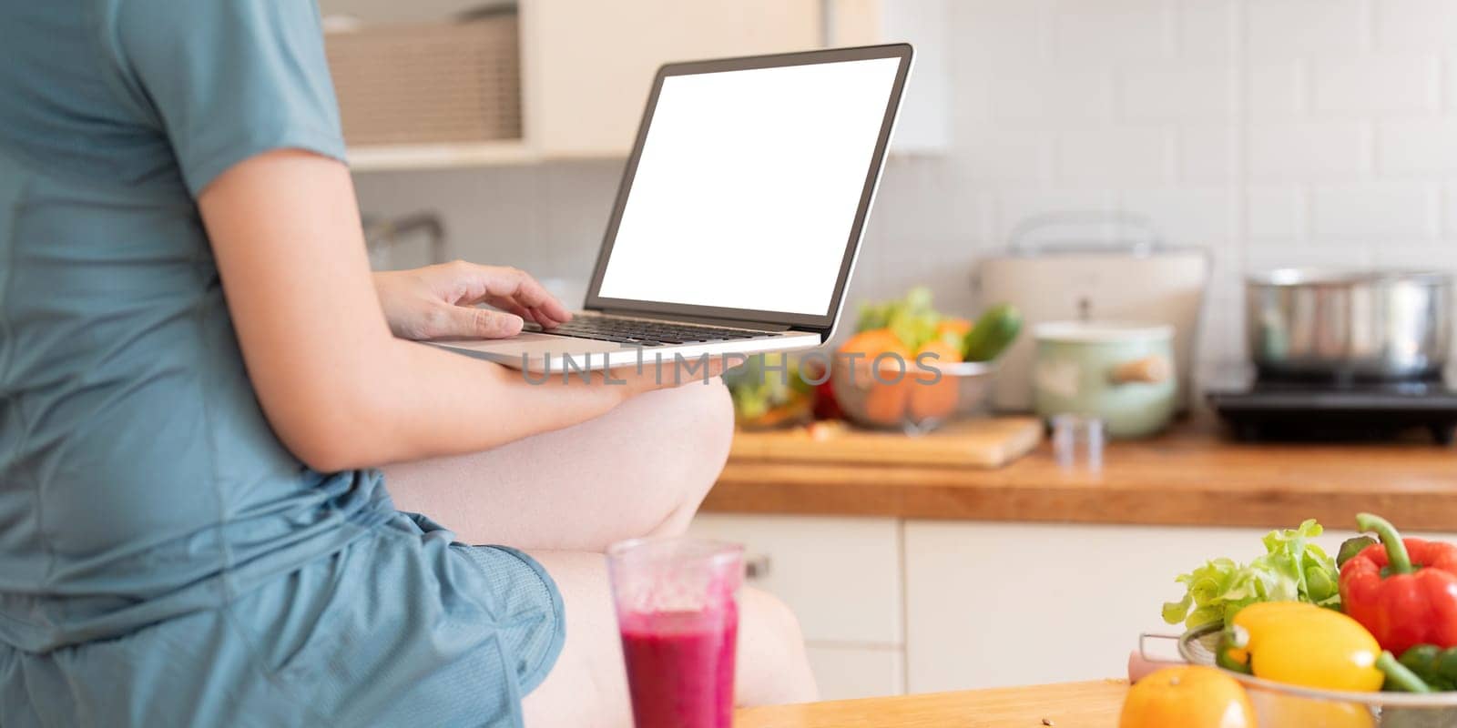 Woman using personal laptop with blank empty screen with copy space, typing on keyboard, looking for new healthy recipes online, mock up by nateemee