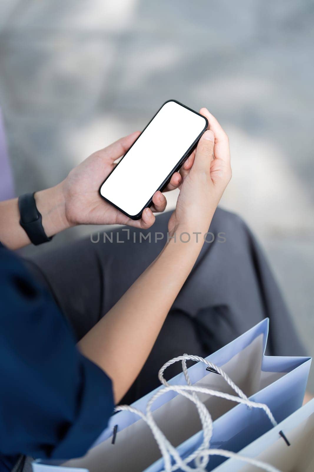 Mobile phone female hand holding in shopping mall. Concept of shopping. Black Friday sale.