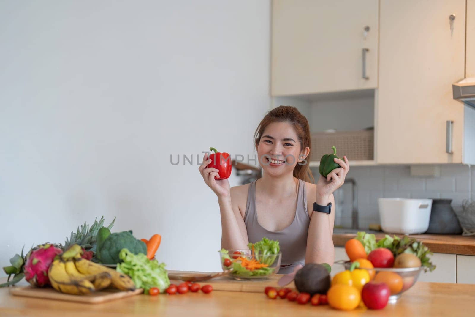 Young Asian healthy beautiful woman with casual clothes is smile and slicing fresh fruit to diet at home in kitchen in holiday.