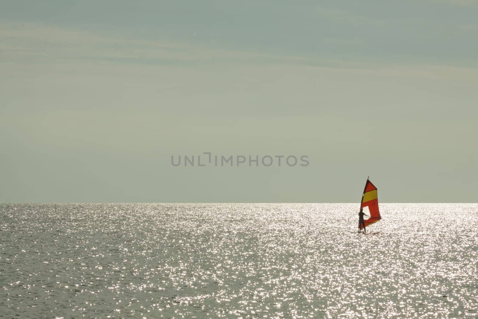 Surfers backlit on the Baltic Sea