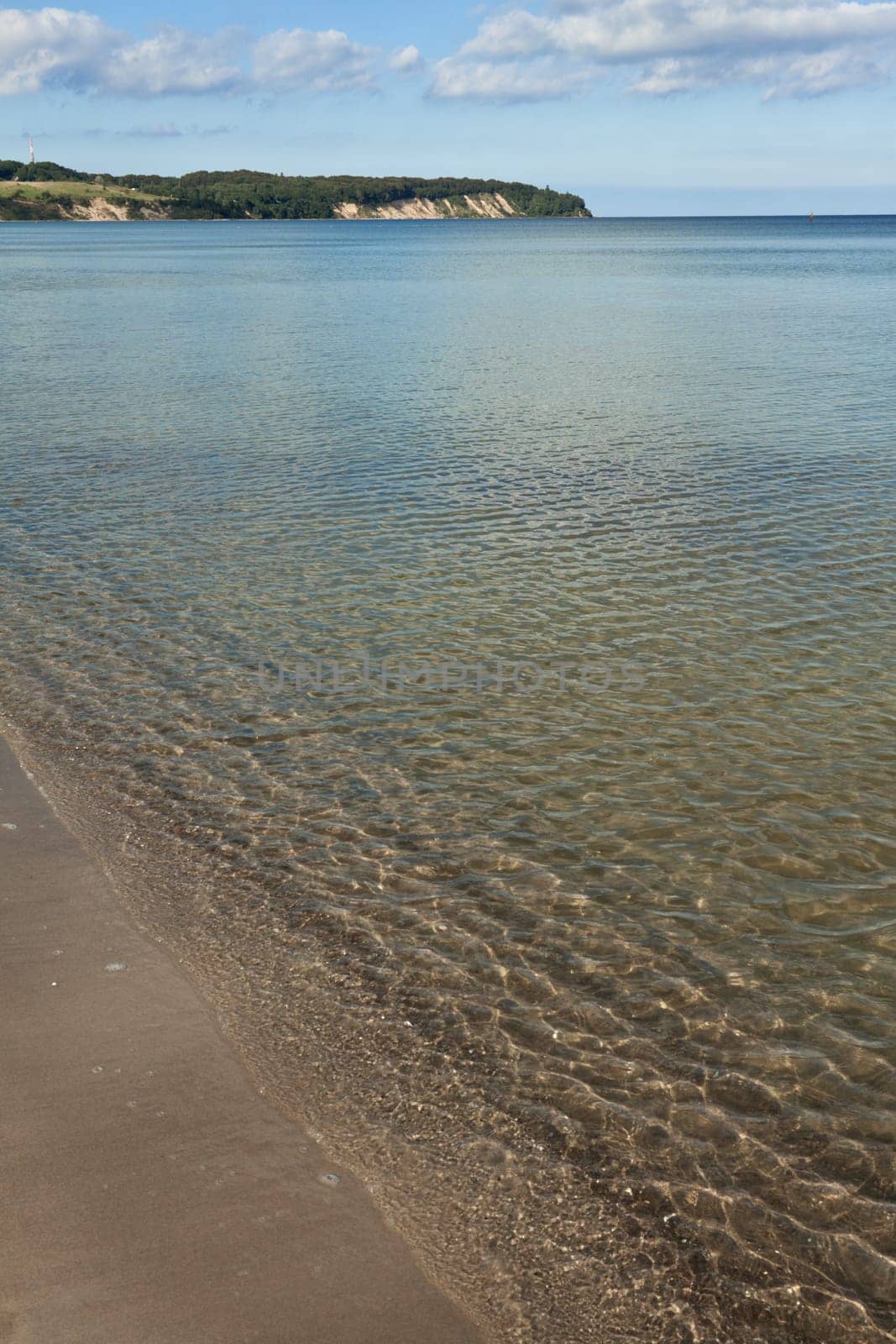 Small waves break with reflections on the beach