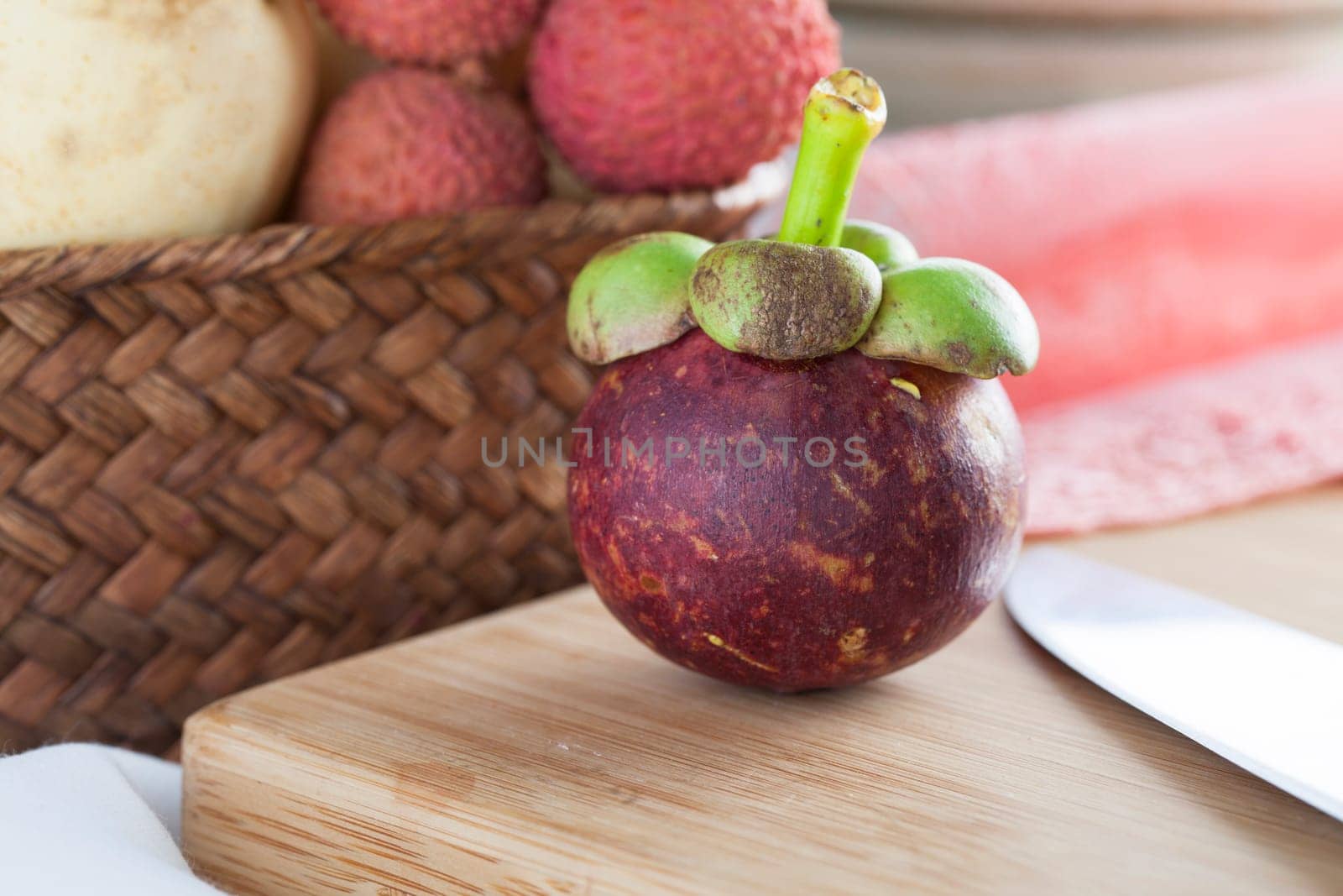 Subtropical mangosteen fruit on cutting board.