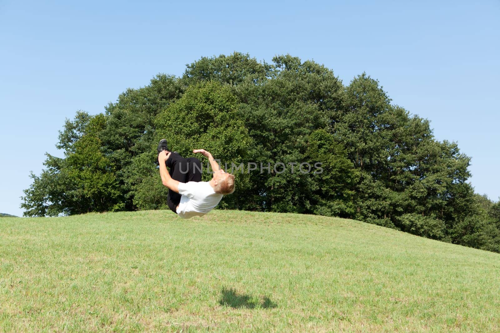 Somersault in nature,young man doing sports training