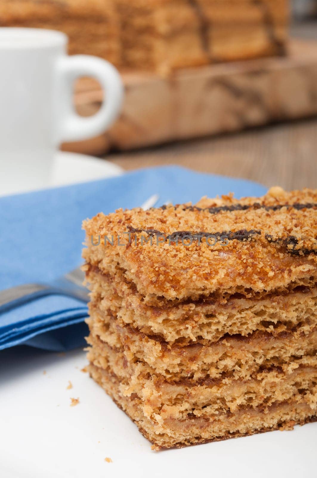 Traditional Honey Cake on Plate and White Cup of Coffee on Table