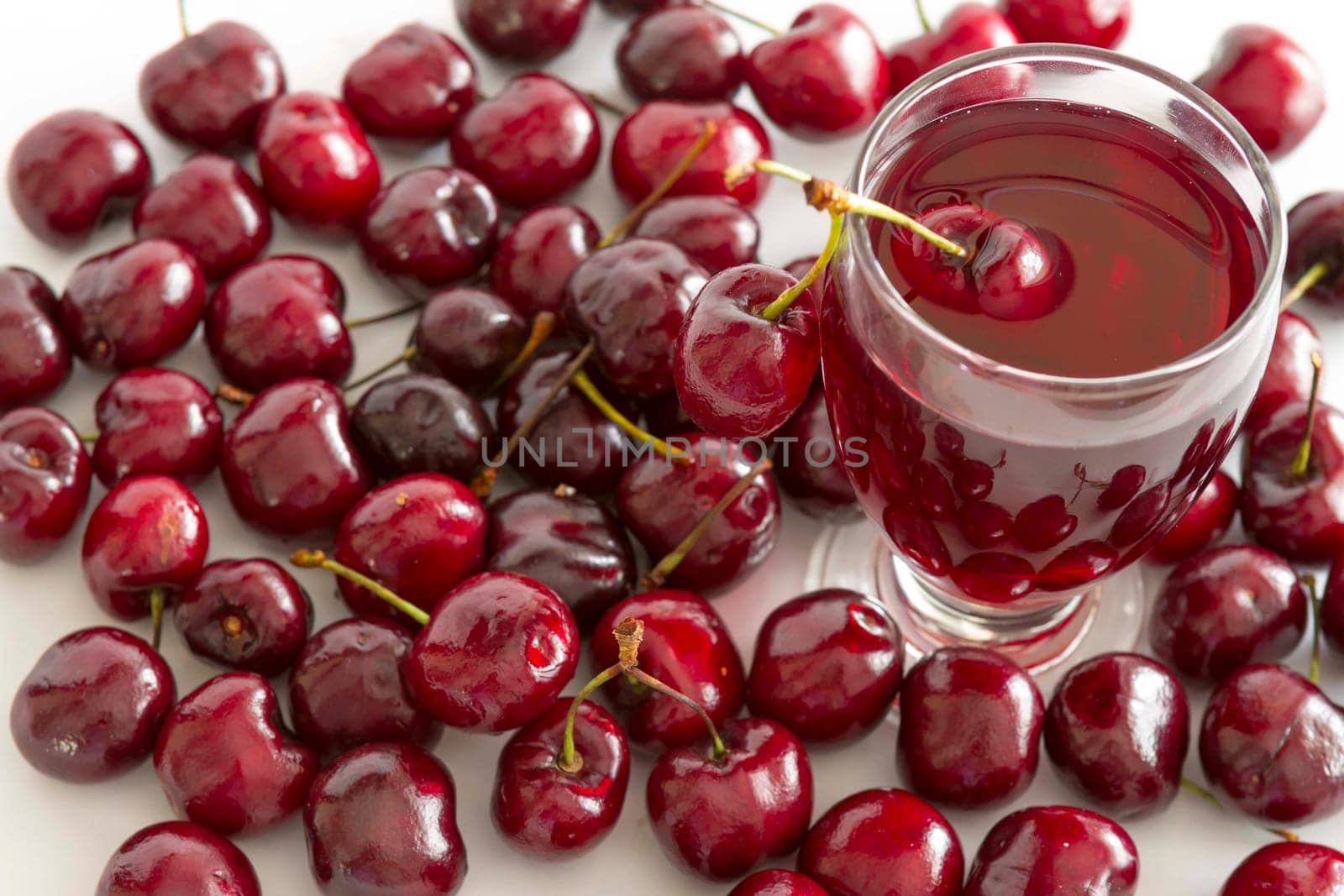 Fresh cold drink with cherry against white background