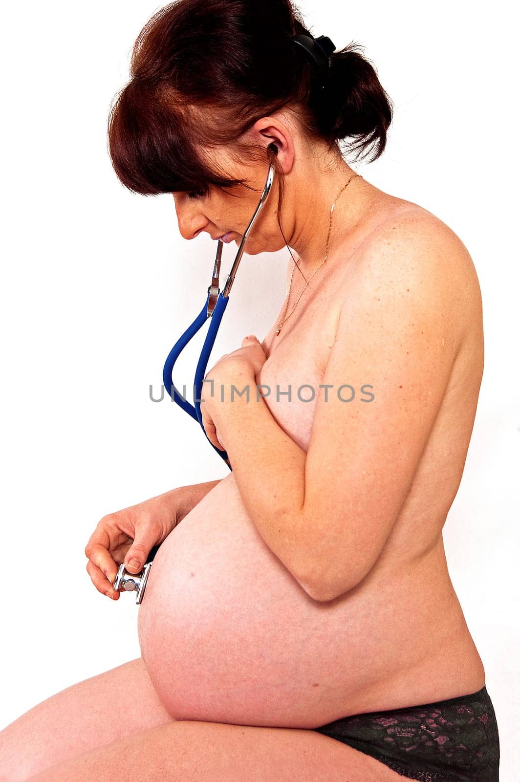 Hands forming a heart shape on a pregnant belly