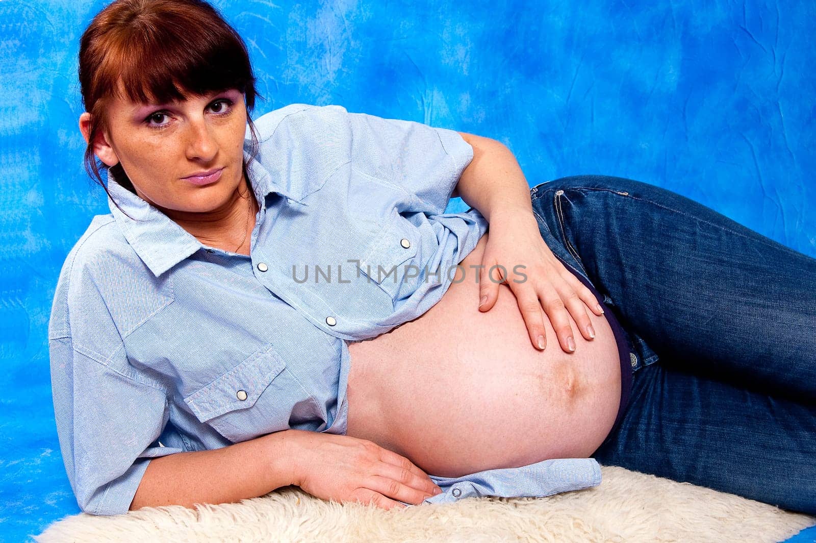 Hands forming a heart shape on a pregnant belly