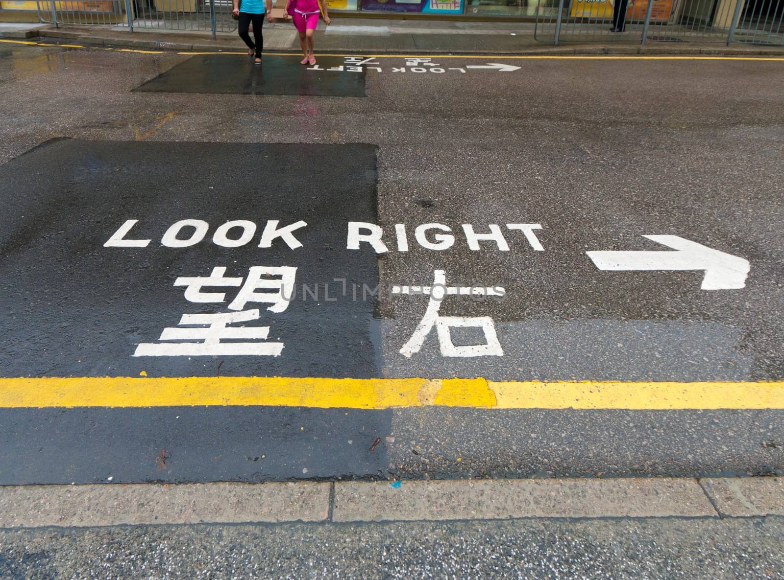 "look right"" sign on a street in hong kong, advising safety for pedestrians"