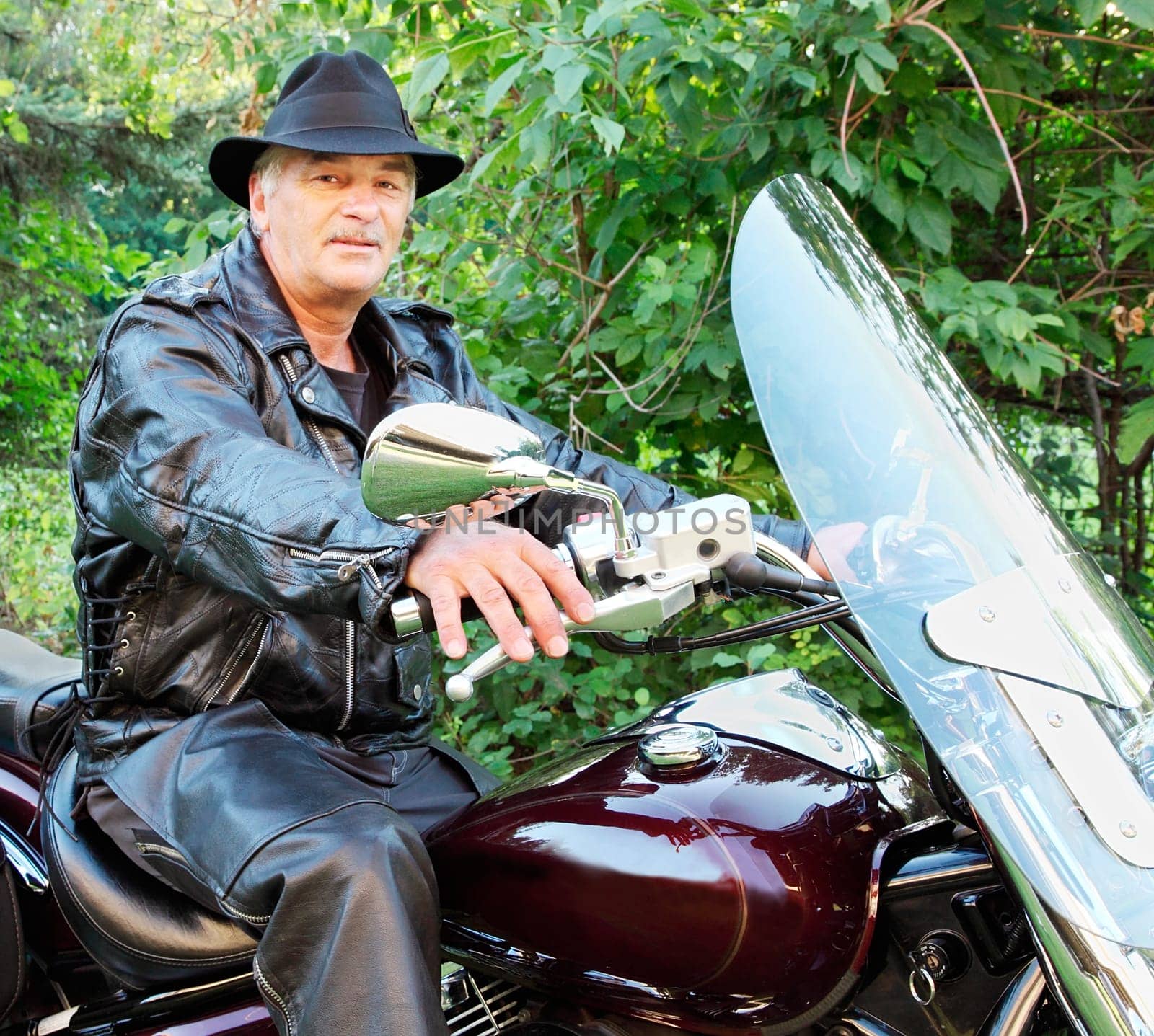 A middle-aged man is riding a motorcycle.