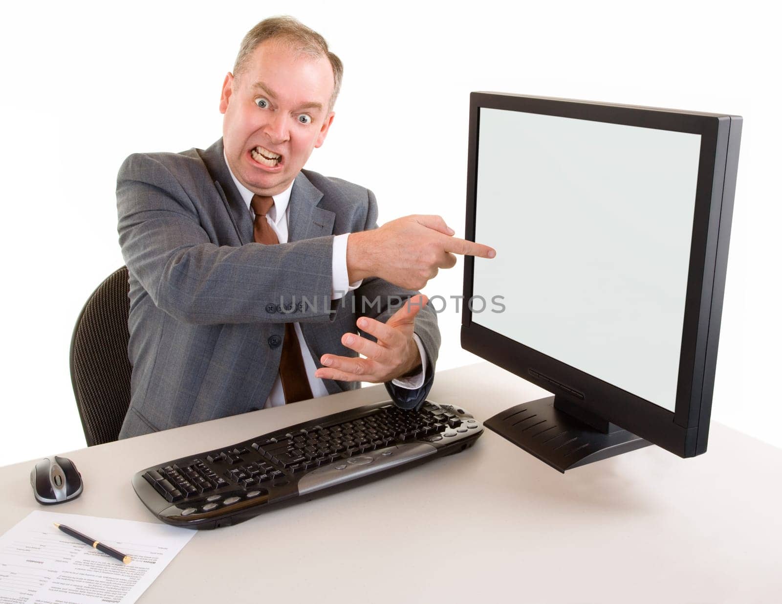 An angry middle aged businessman is pointing to the monnitor