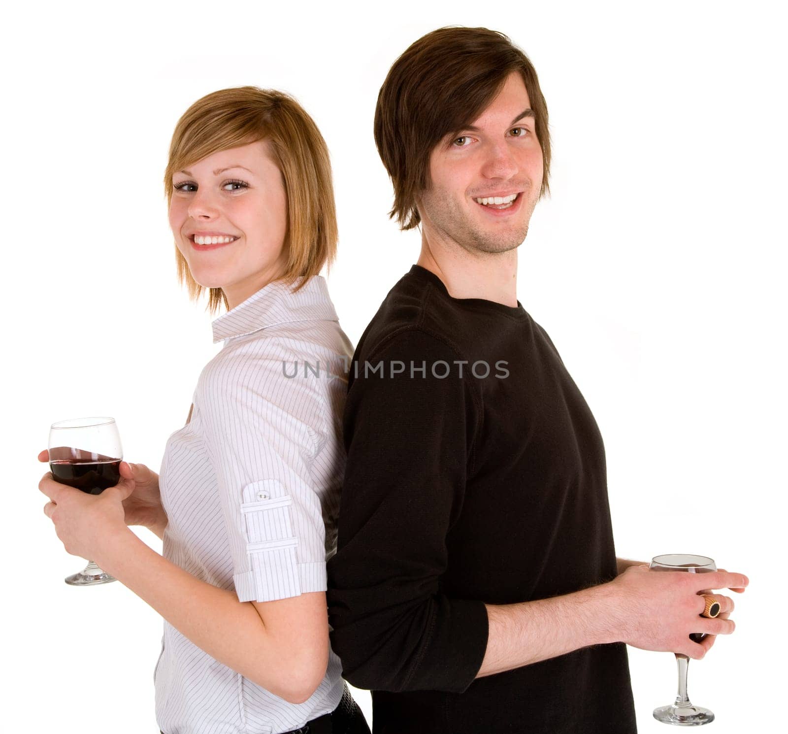 While standing back to back, a young couple are having red wine.
