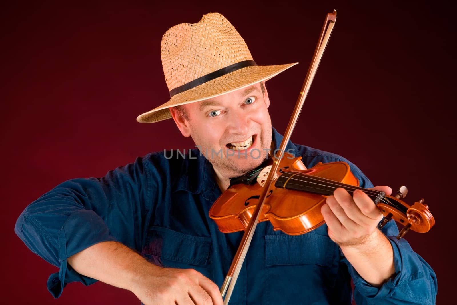 A man is playing country music on the fiddle.