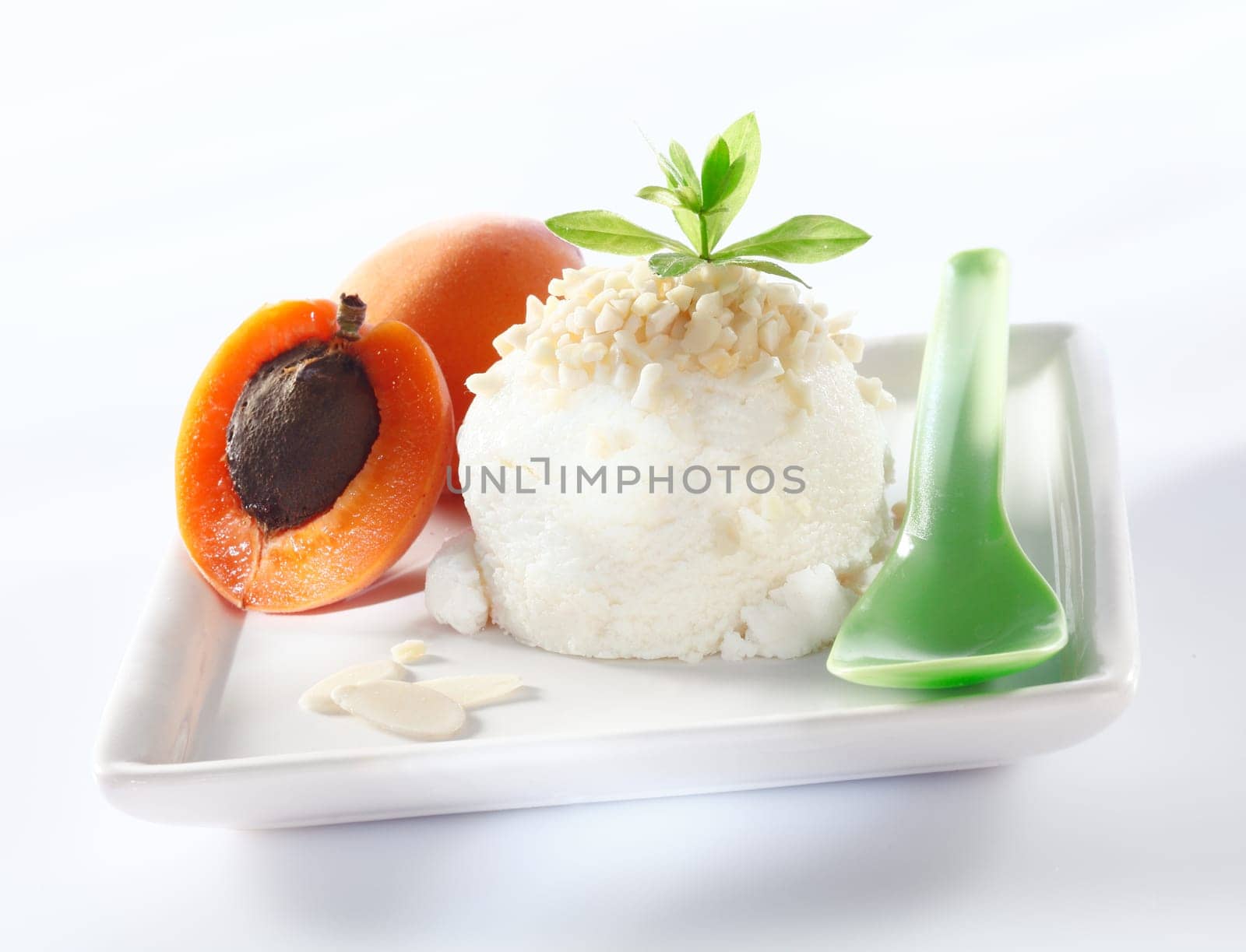 Sorbet icecream with almond topping and apricots served on a square white plate