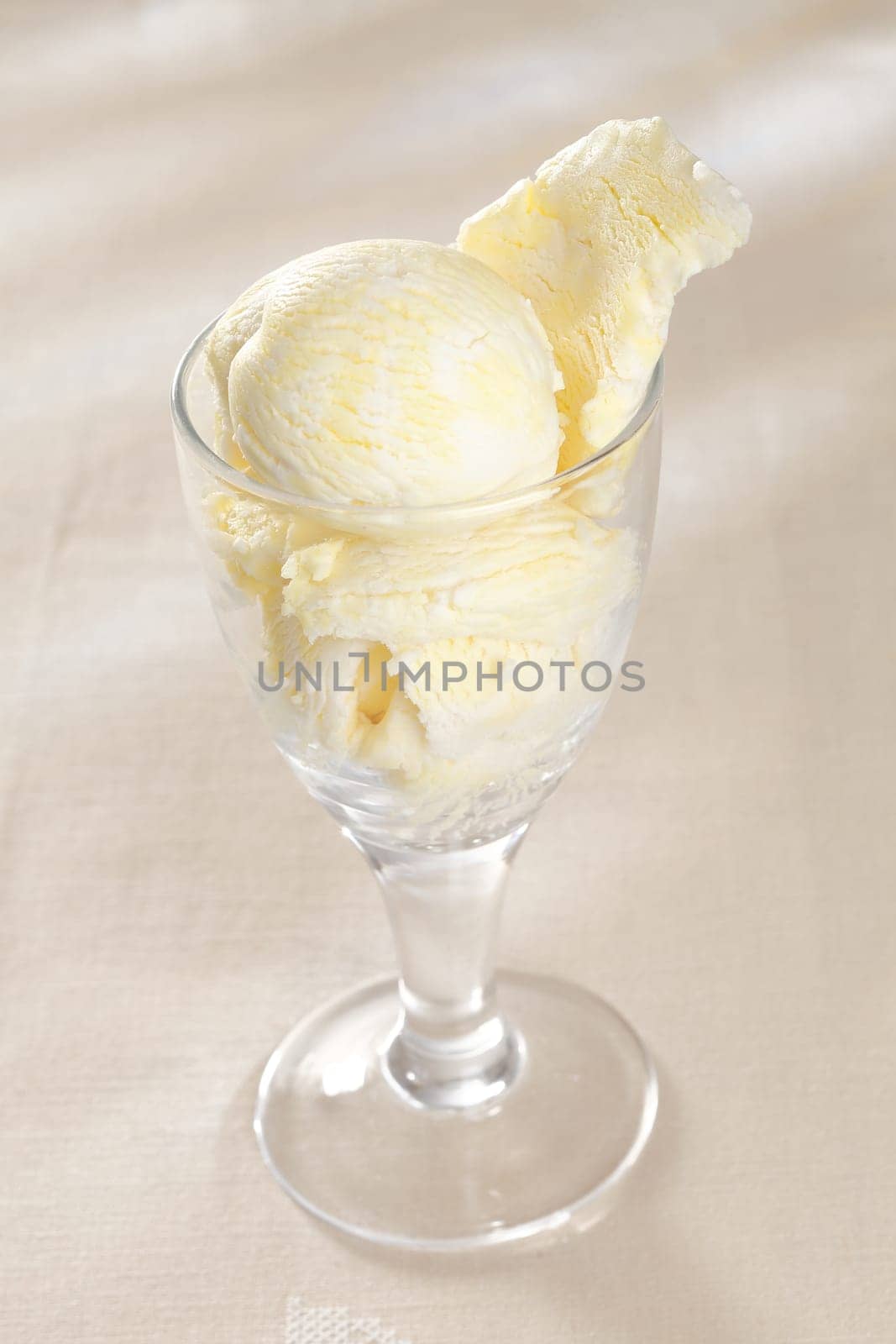 High angle view of a glass filled with delicious creamy vanilla ice-cream on a white background