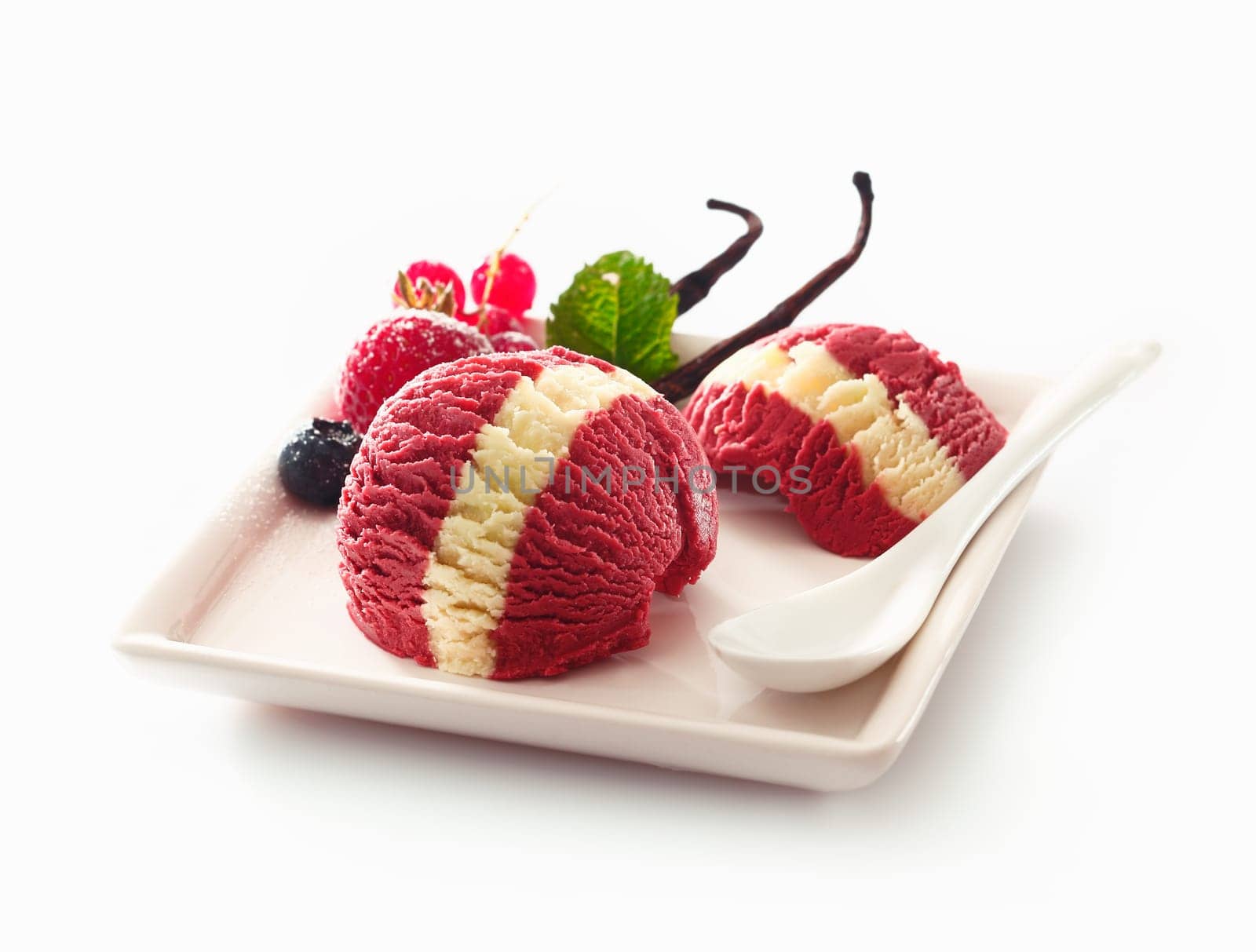 Serving on a plate of decorative berry and vanilla ice-cream with a distinctive white stripe on a white studio background