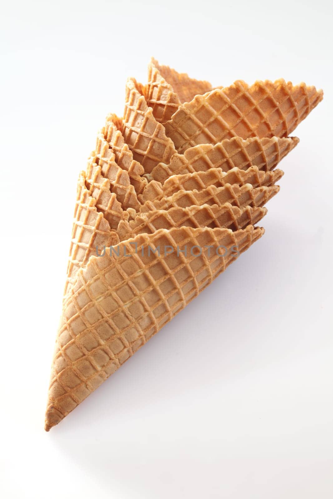 Stack of wide waffle pattern wafer ice-cream cones suitable for double scoop servings on white