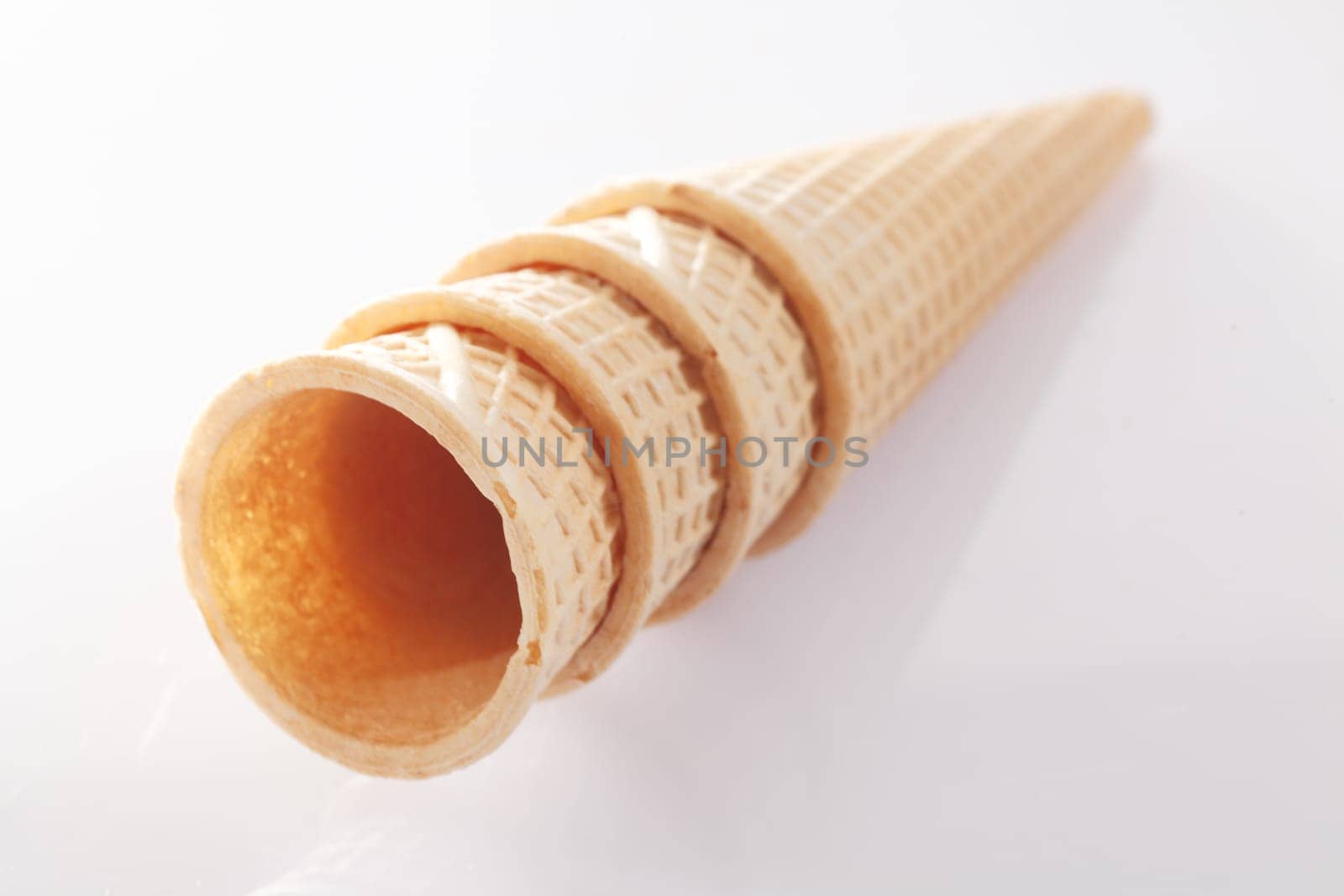 Stack of waffle pattern wafer icecream cones on white background. Visit my portfolio for more.