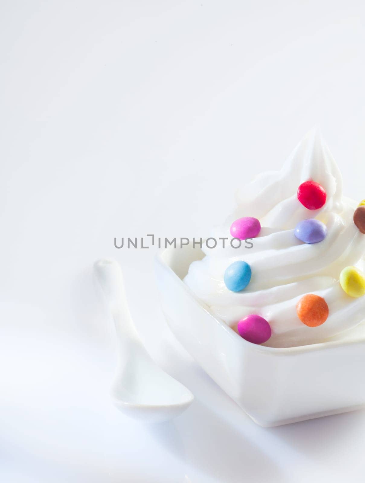 Soft-serve icecream whirl with colourful round candy ready for a childs bithday party with copyspace