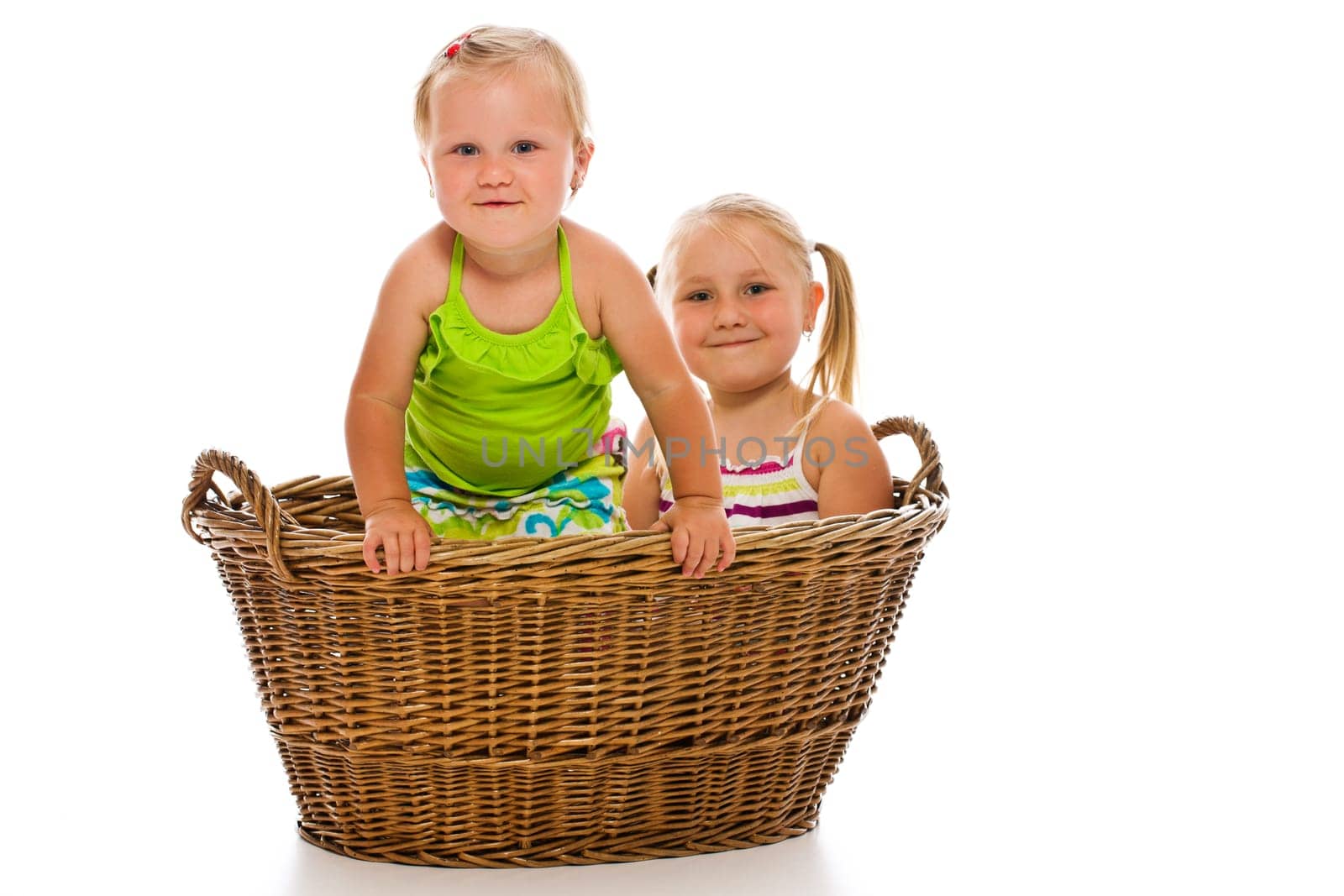 siblings in big basket on white background