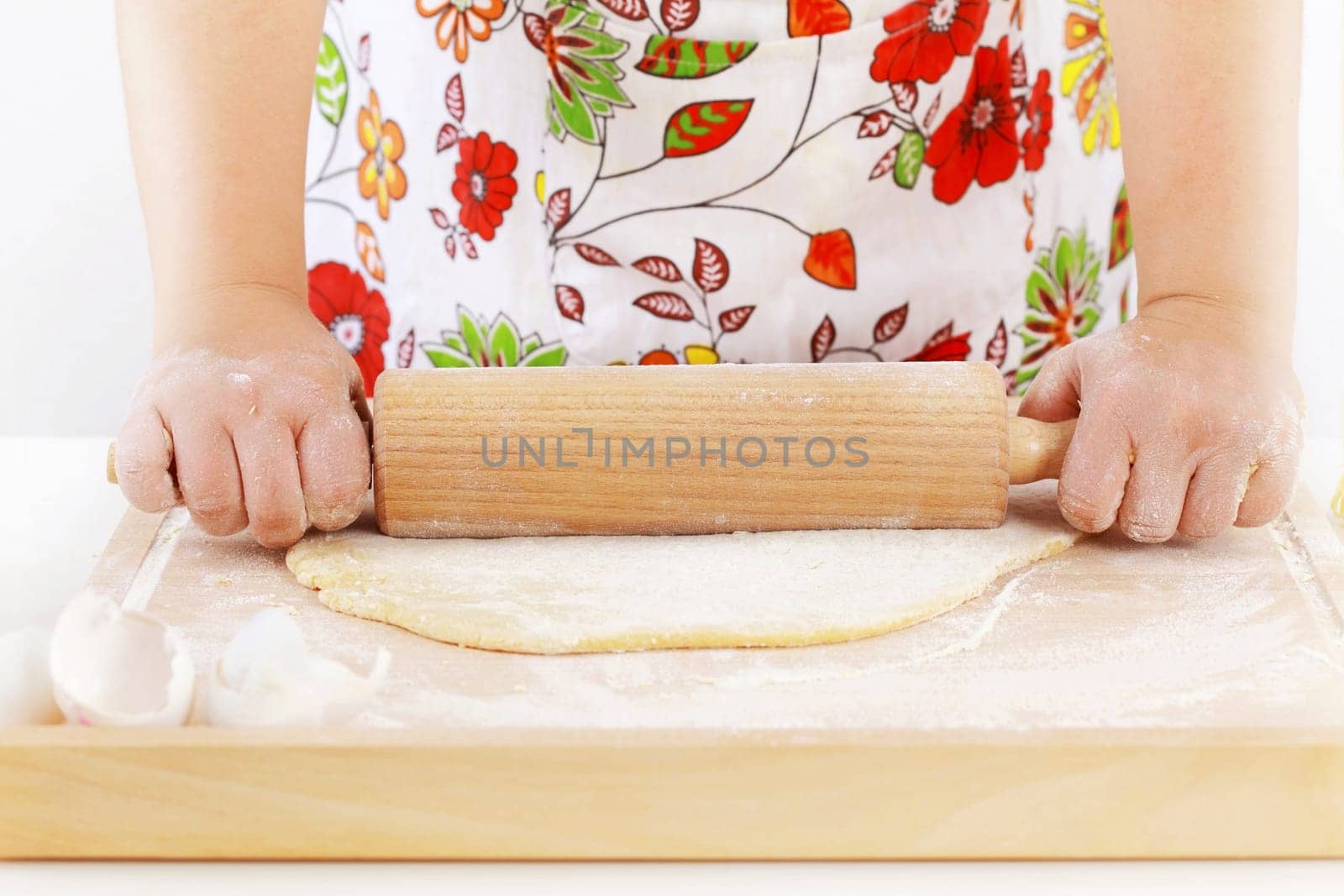 Details of woman&#039 s hands rolling dough using rolling pin