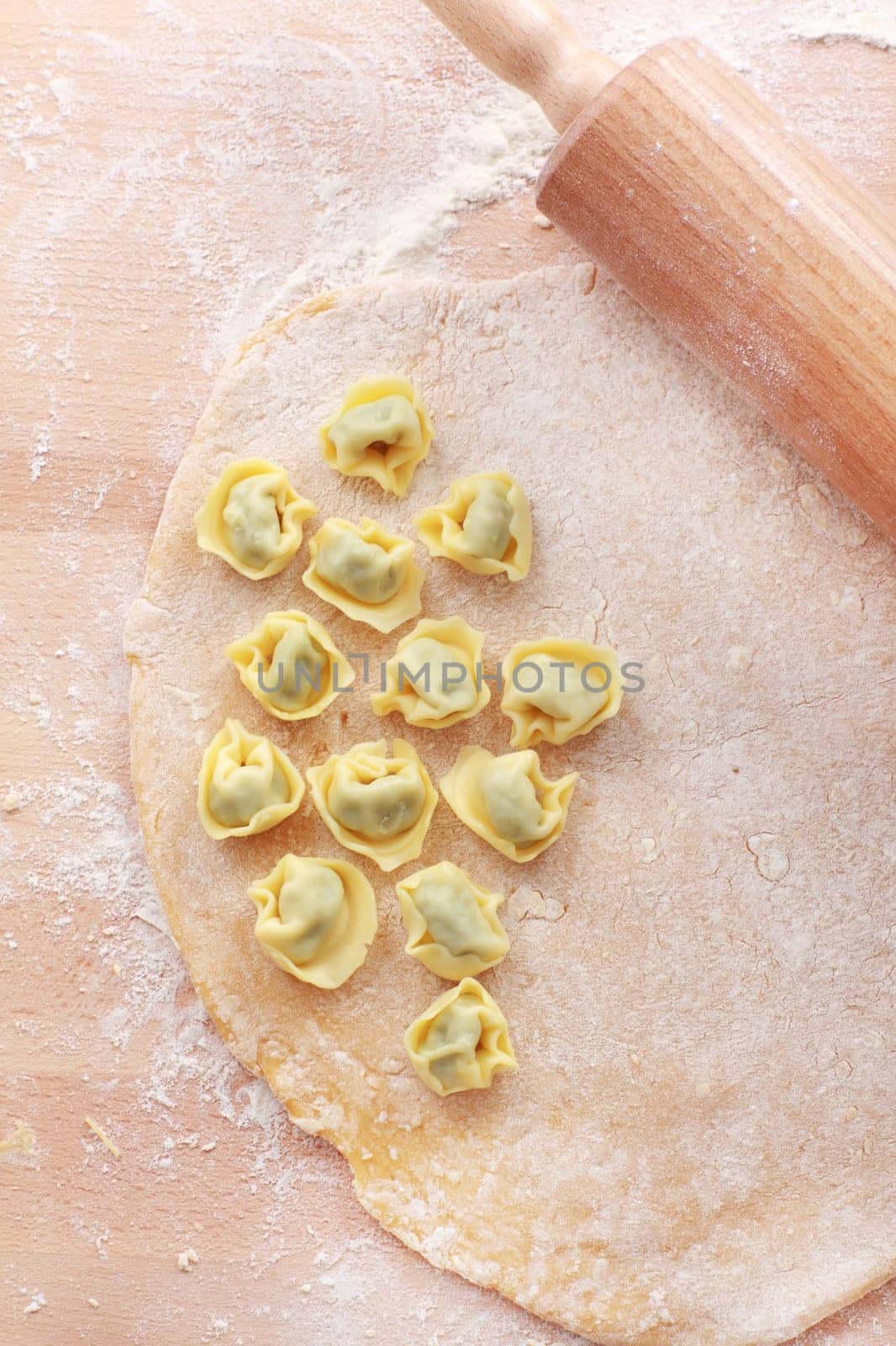 Dough with raw tortellini and rolling pin