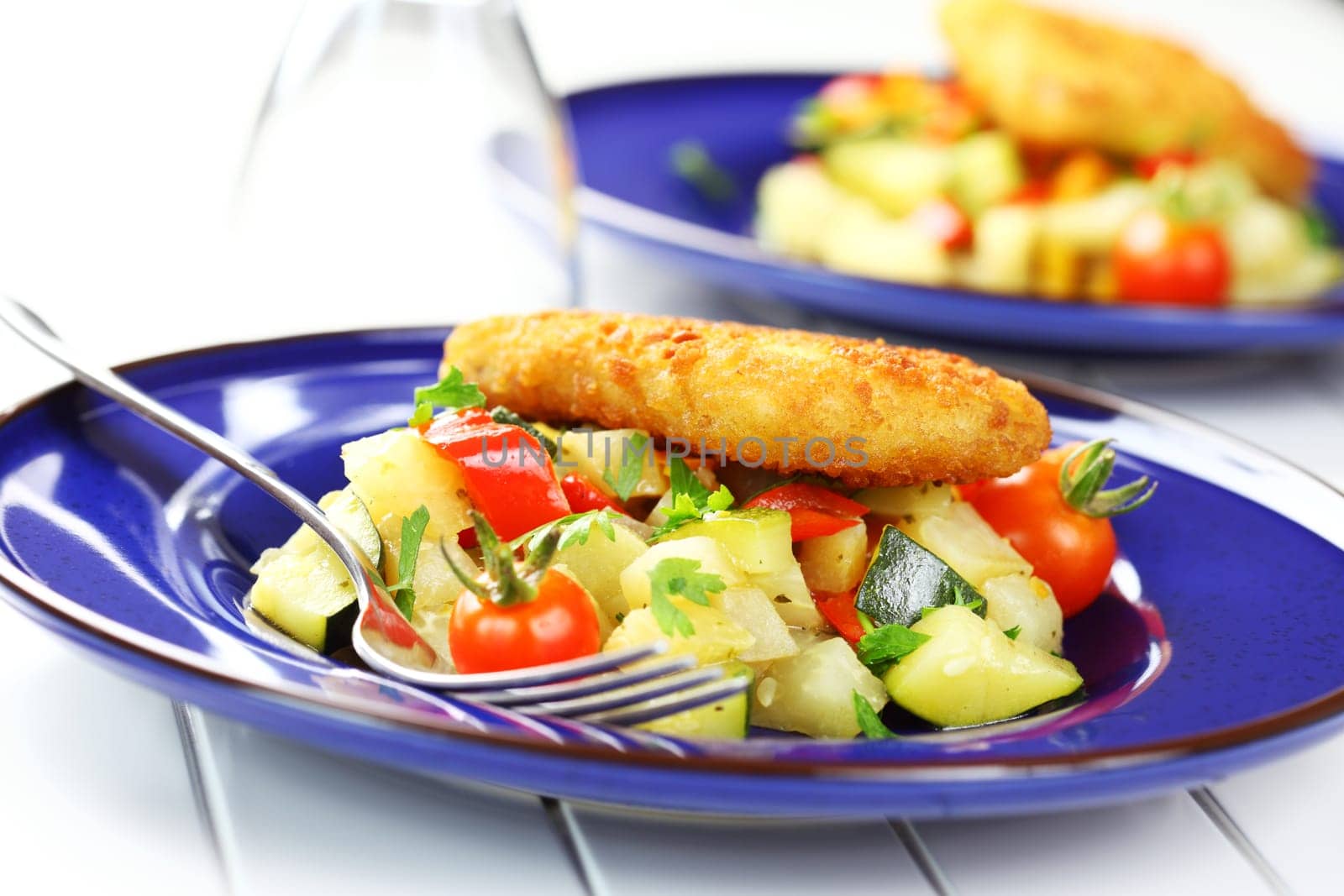 Delicious fried fish on vegetables