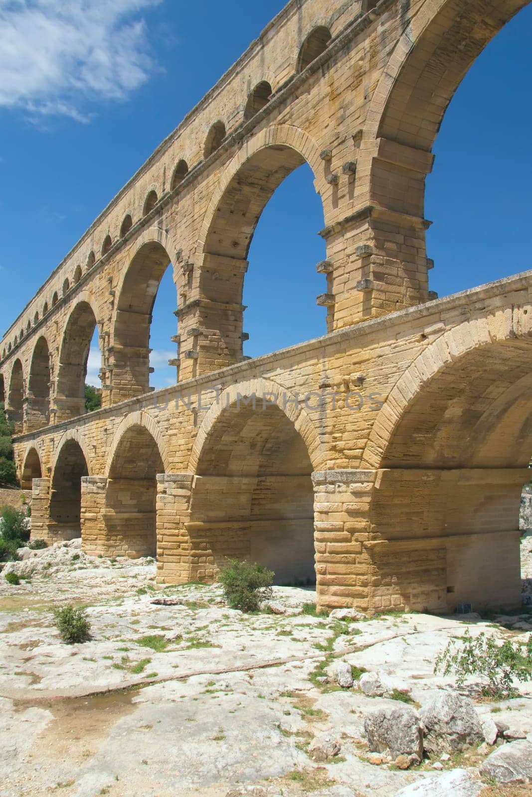 The Pont du Gard is an ancient Roman aqueduct bridge that crosses the Gardon River in southern France. Vertically.