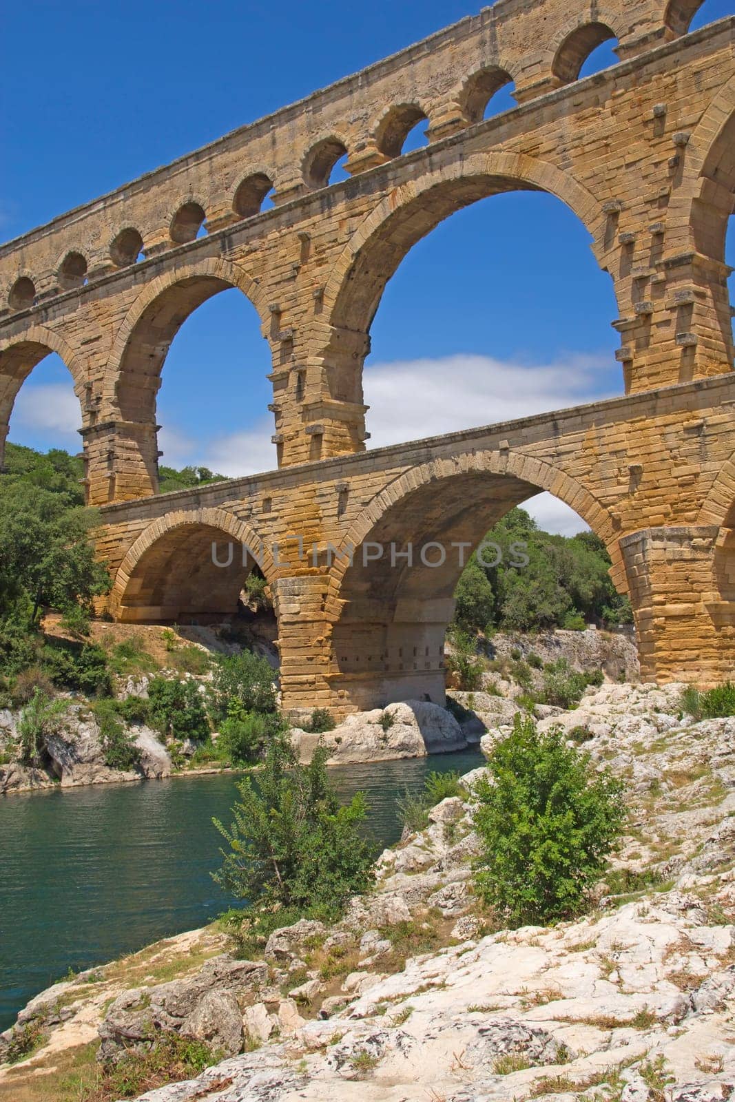 The Pont du Gard is an ancient Roman aqueduct bridge that crosses the Gardon River in southern France. Vertically.