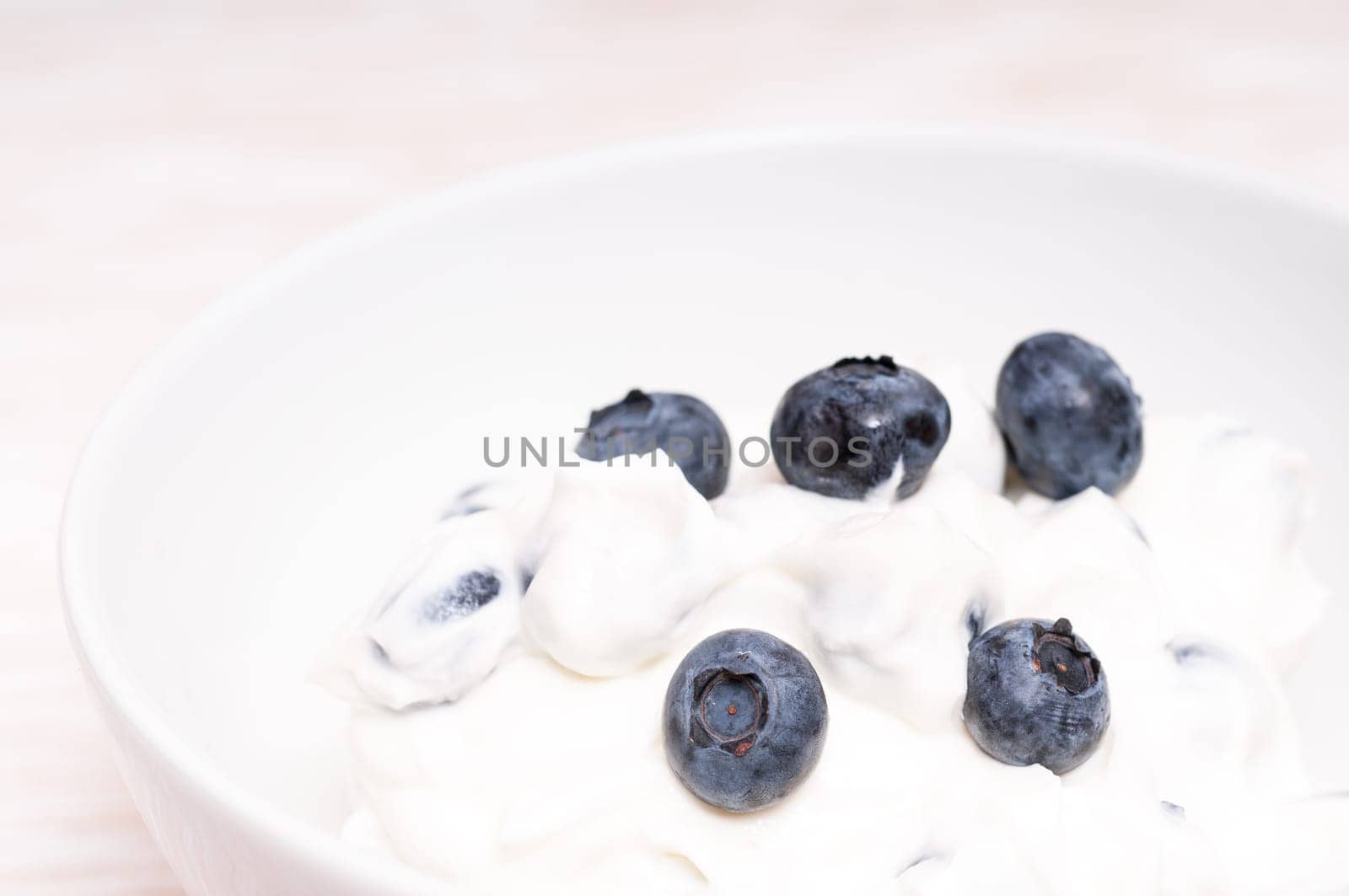 Blueberries in cottage cheese and a white bowl