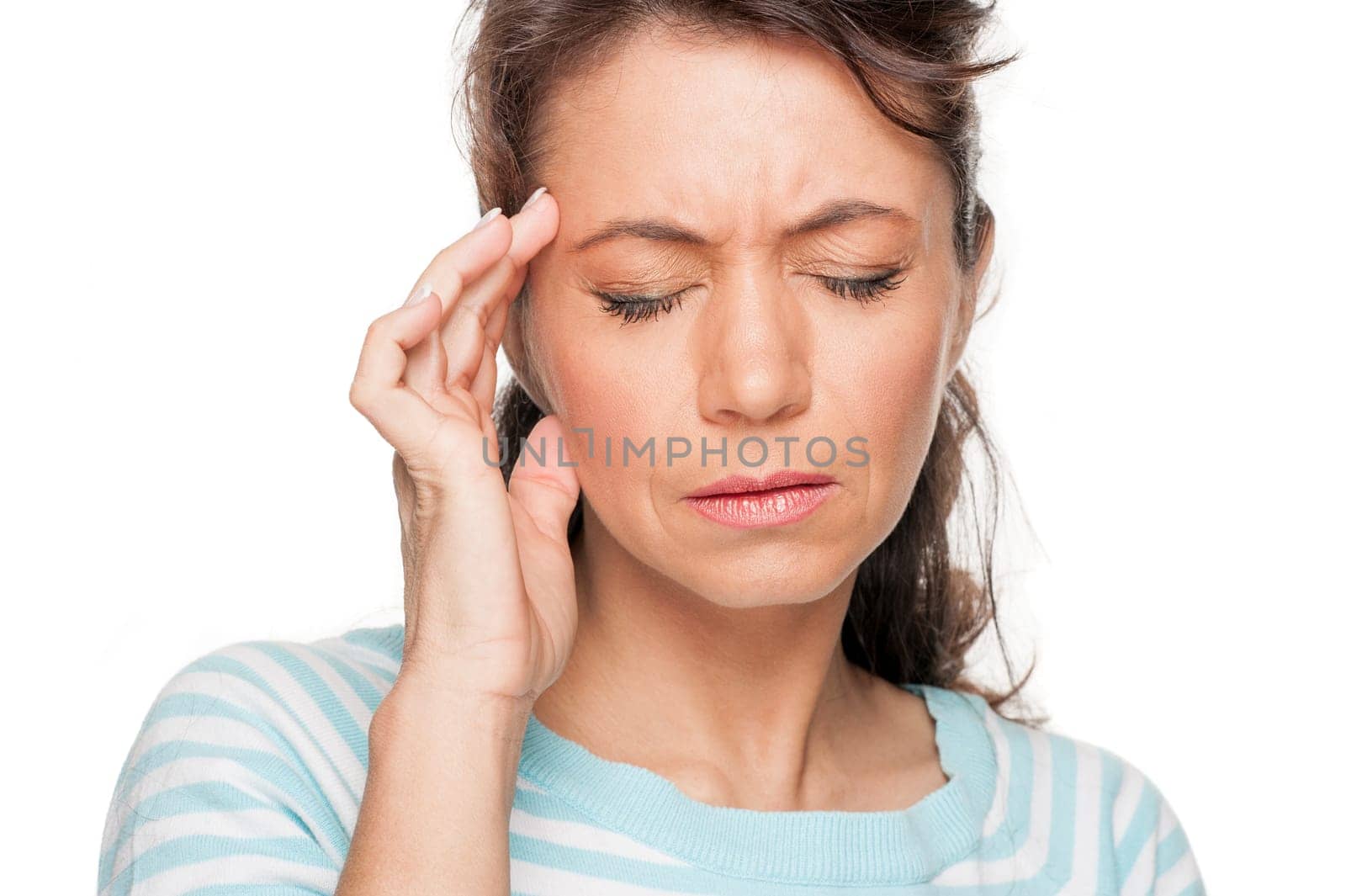 Young woman in front of white background with headache