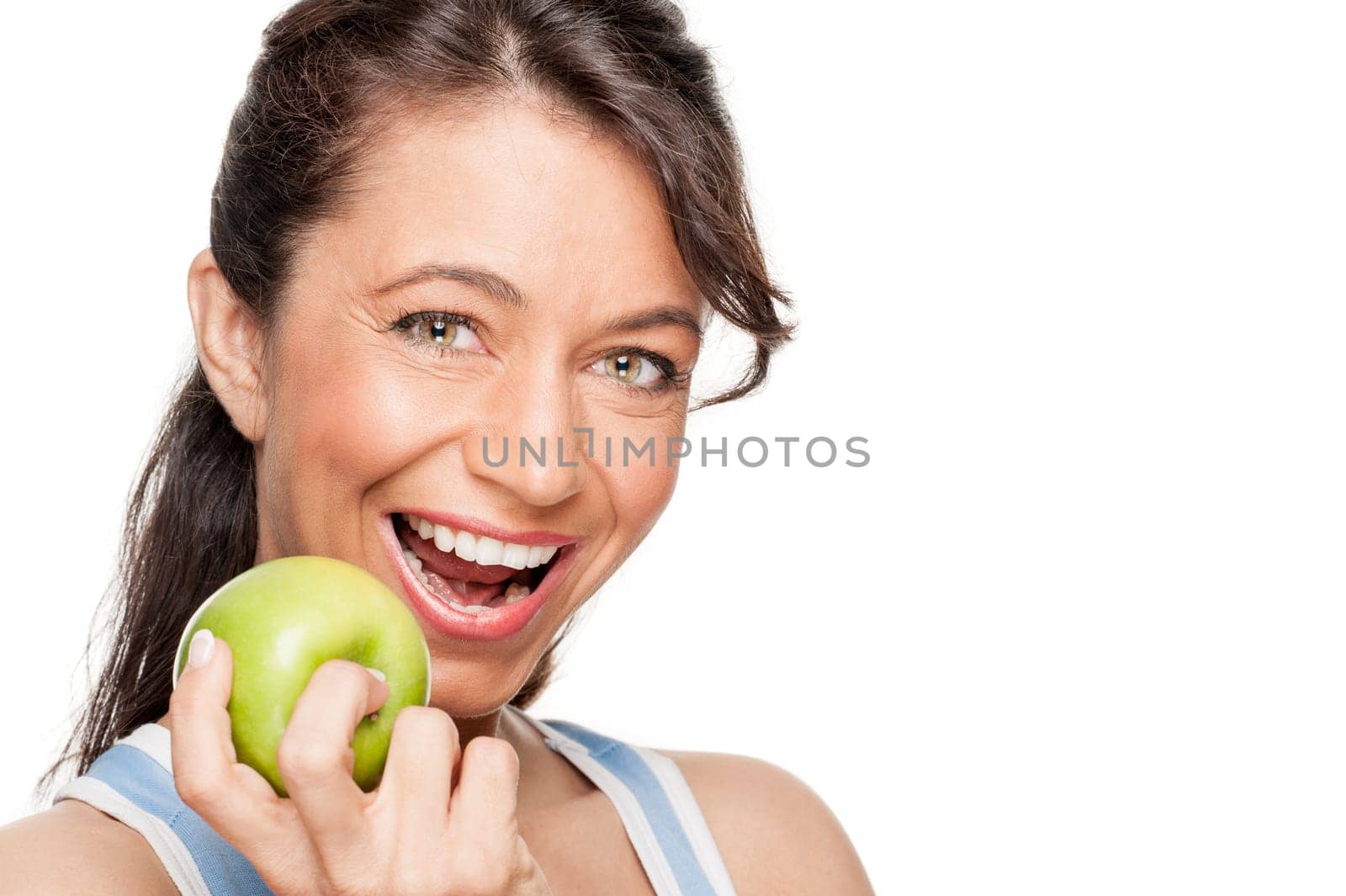 Smiling woman in front of white background with a green apple
