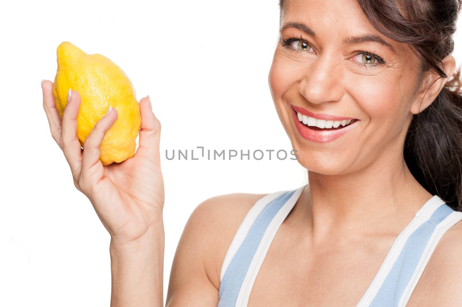 Smiling woman in front of white background with lemon