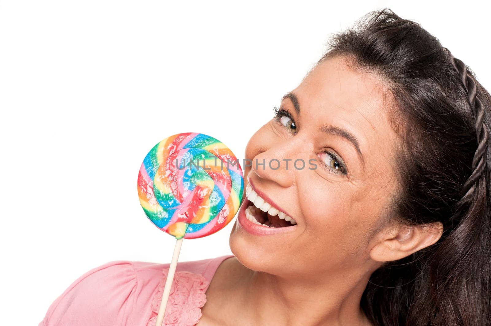 Smiling woman with a lollipop against a white background