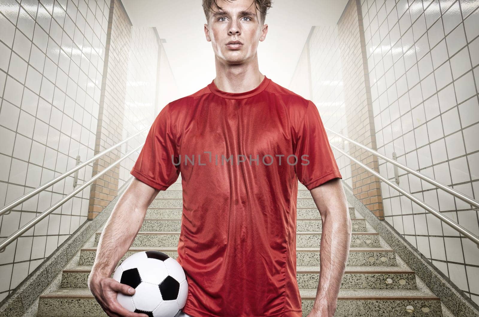 Young footballer with a soccer ball in the stadium tunnel