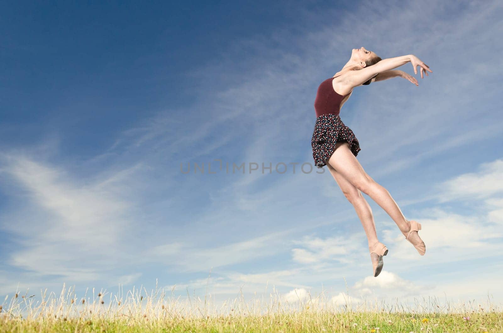 Young woman jumping in front of blue sky