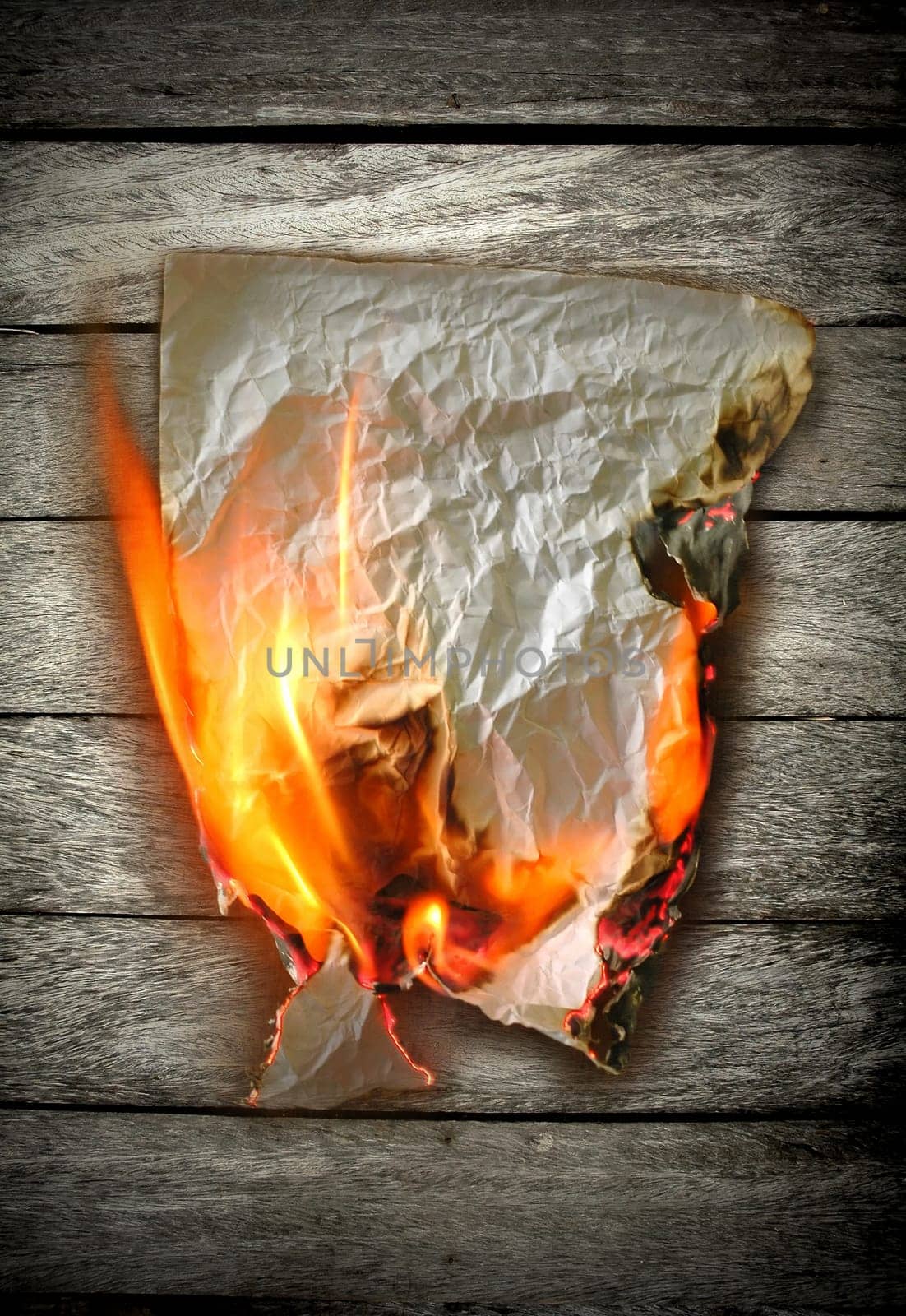 burning paper on wood  background